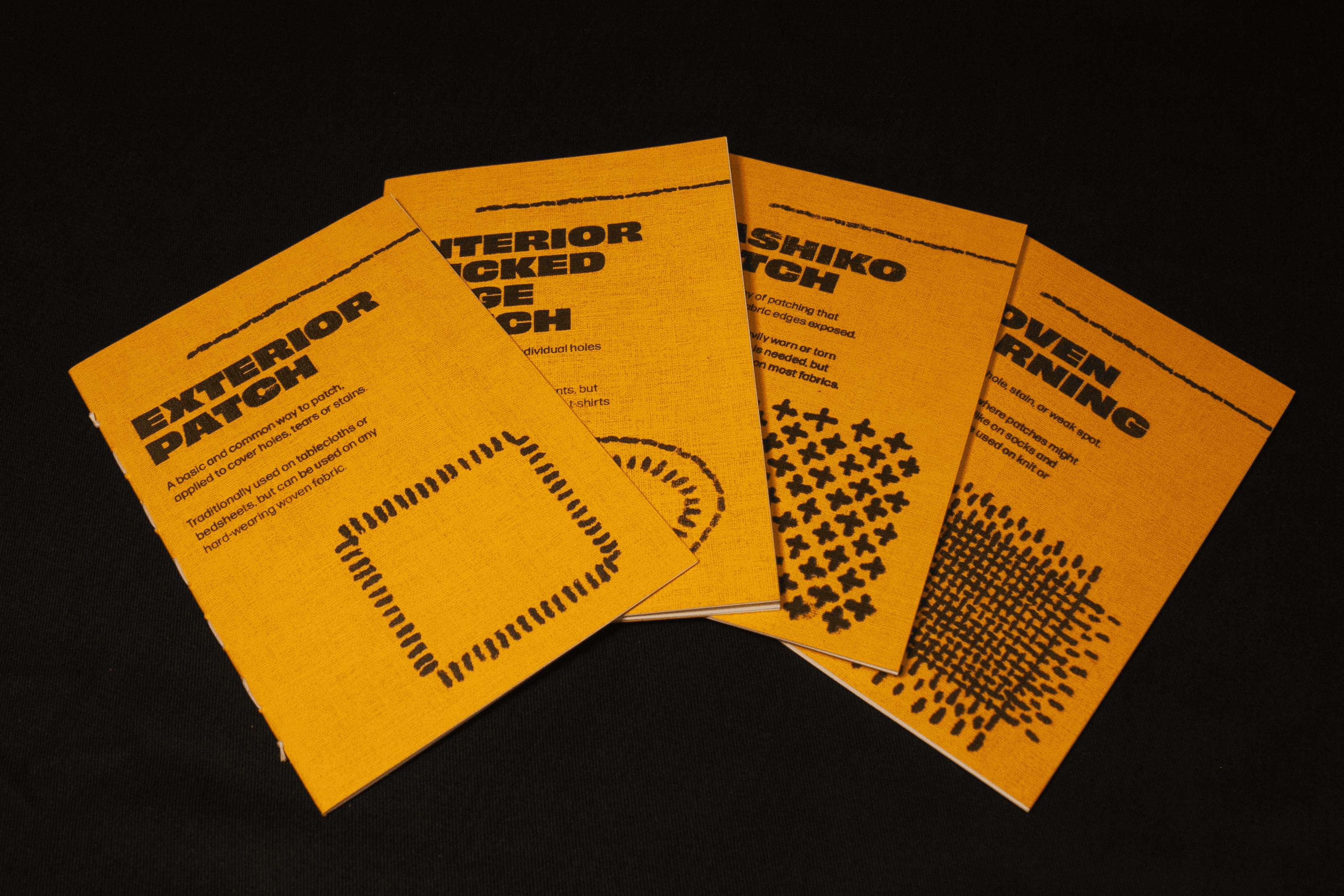 Four yellow booklets about different mending techniques