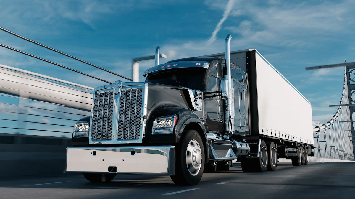 Black semi-truck driving on bridge representing semi truck insurance cost.