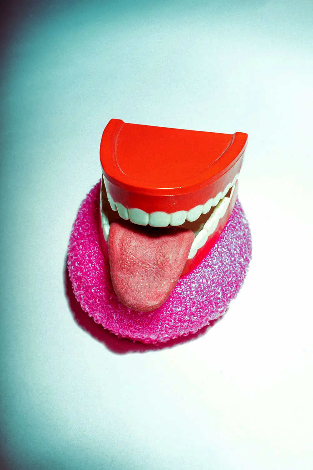 A colorful, oversized model of lips and a tongue on a gradient background, used for educational purposes.