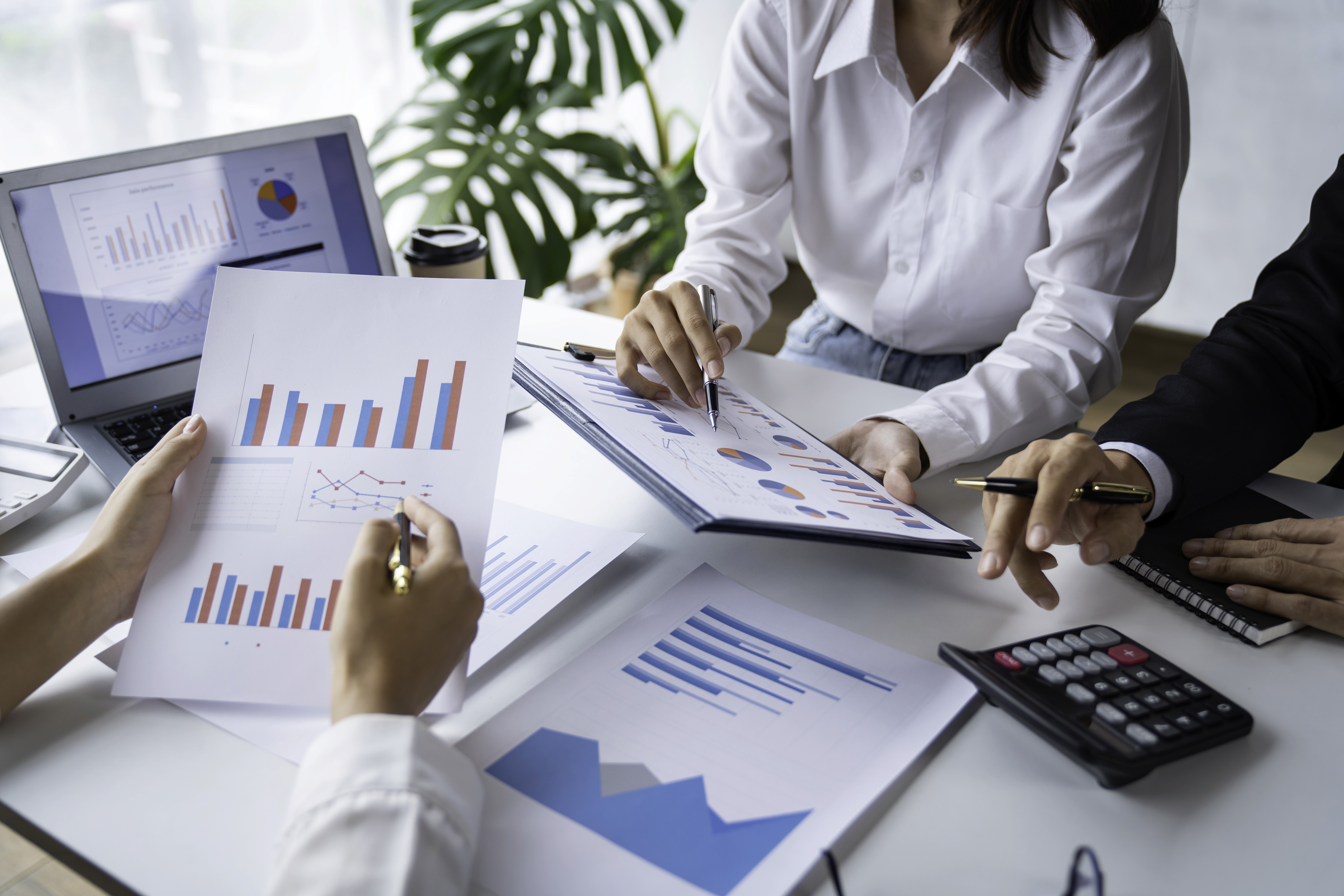 3 kişilik sadece ellerin gözüktüğü toplantı ve grafik