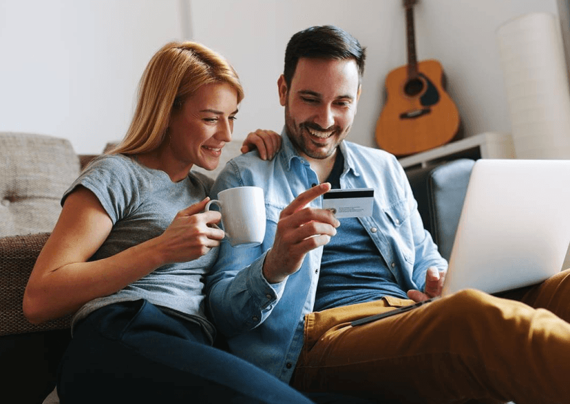 Happy couple shopping online with laptop and credit card