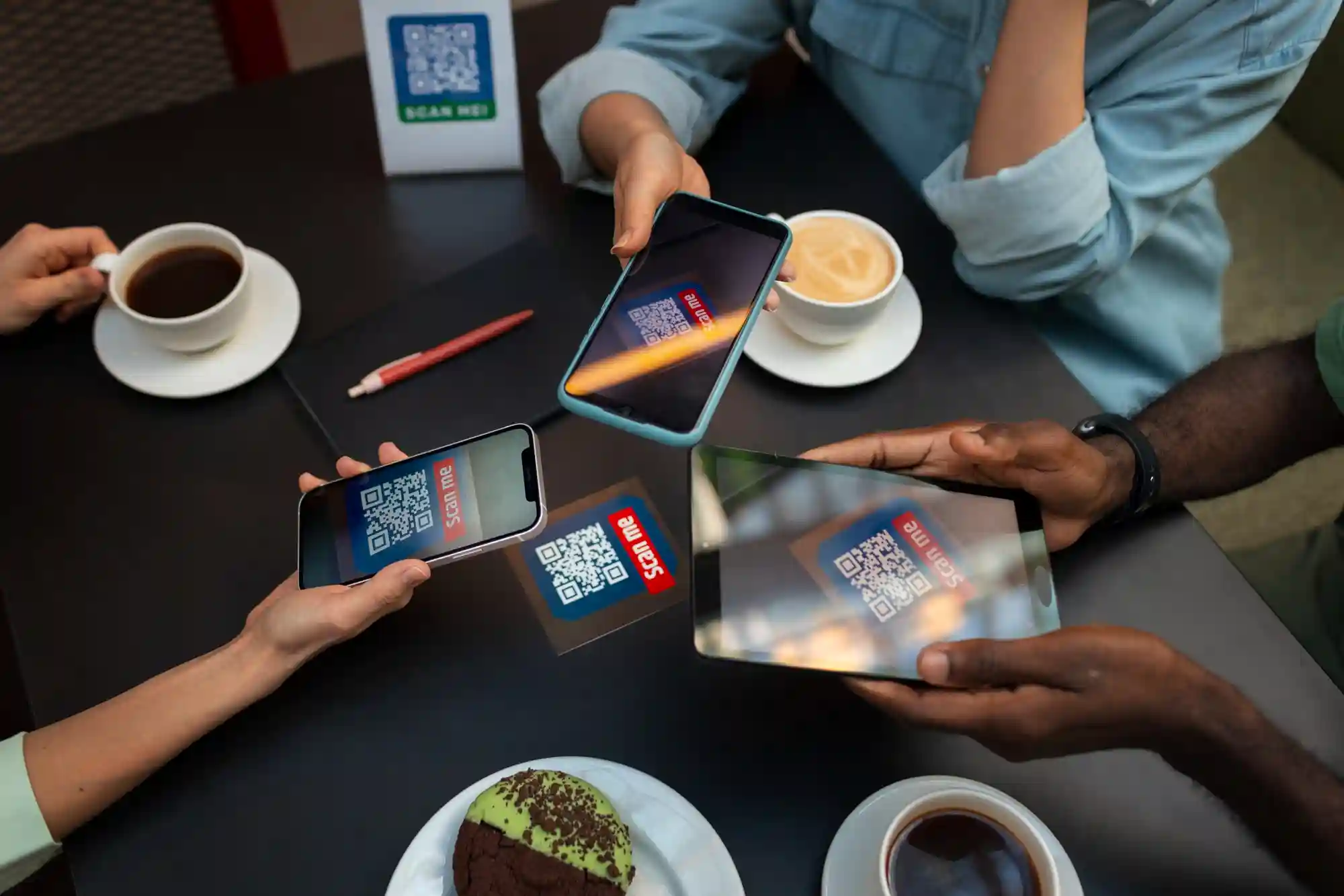A group of people use their smartphones to scan a QR code on a cafe table for digital access.