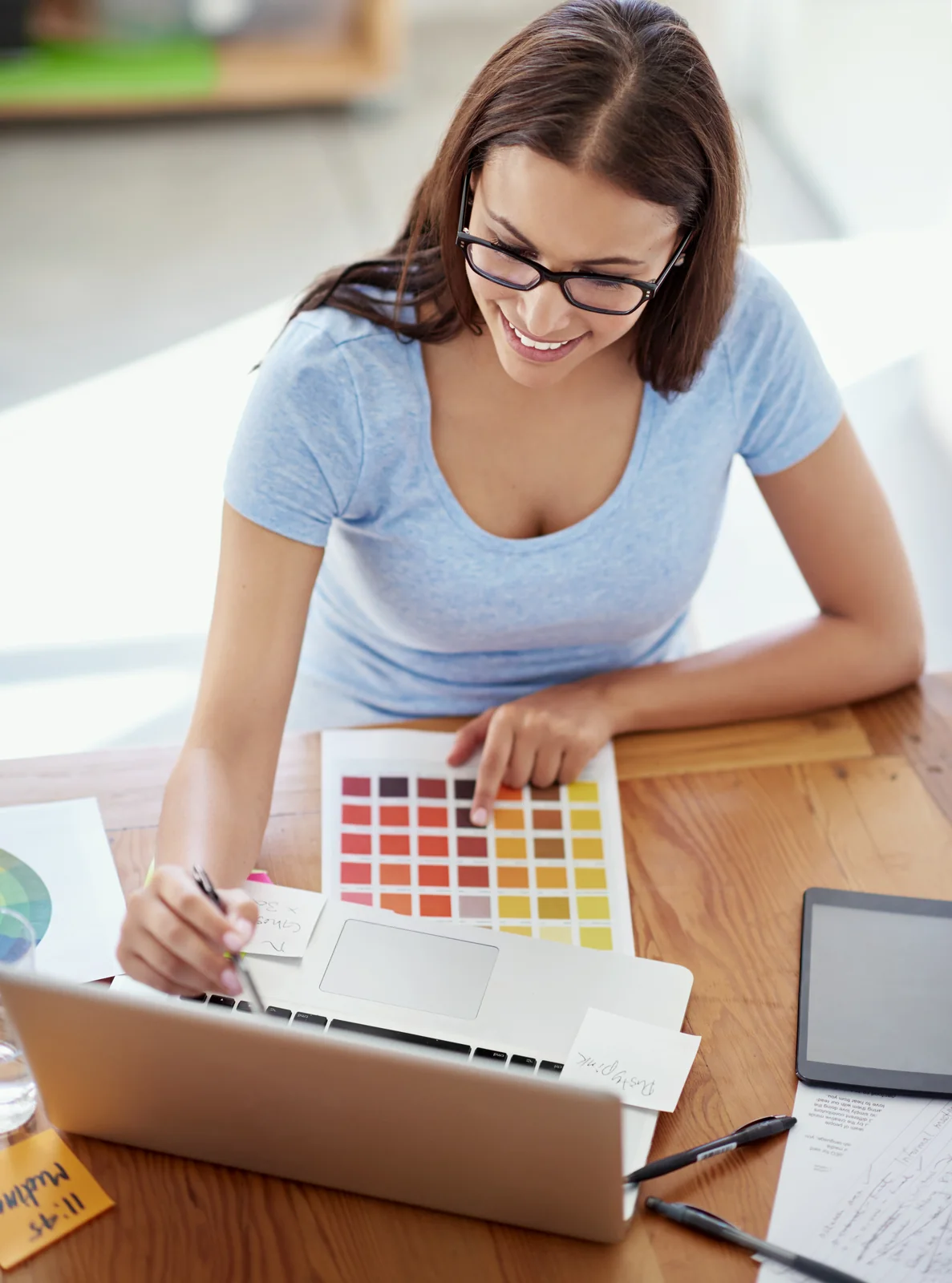 Young Woman Designs with Color Palette and Laptop