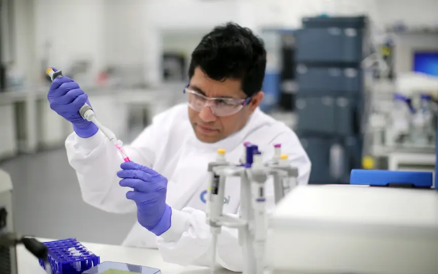 A photo of a lab scientist holding a pipette conducting an experiment