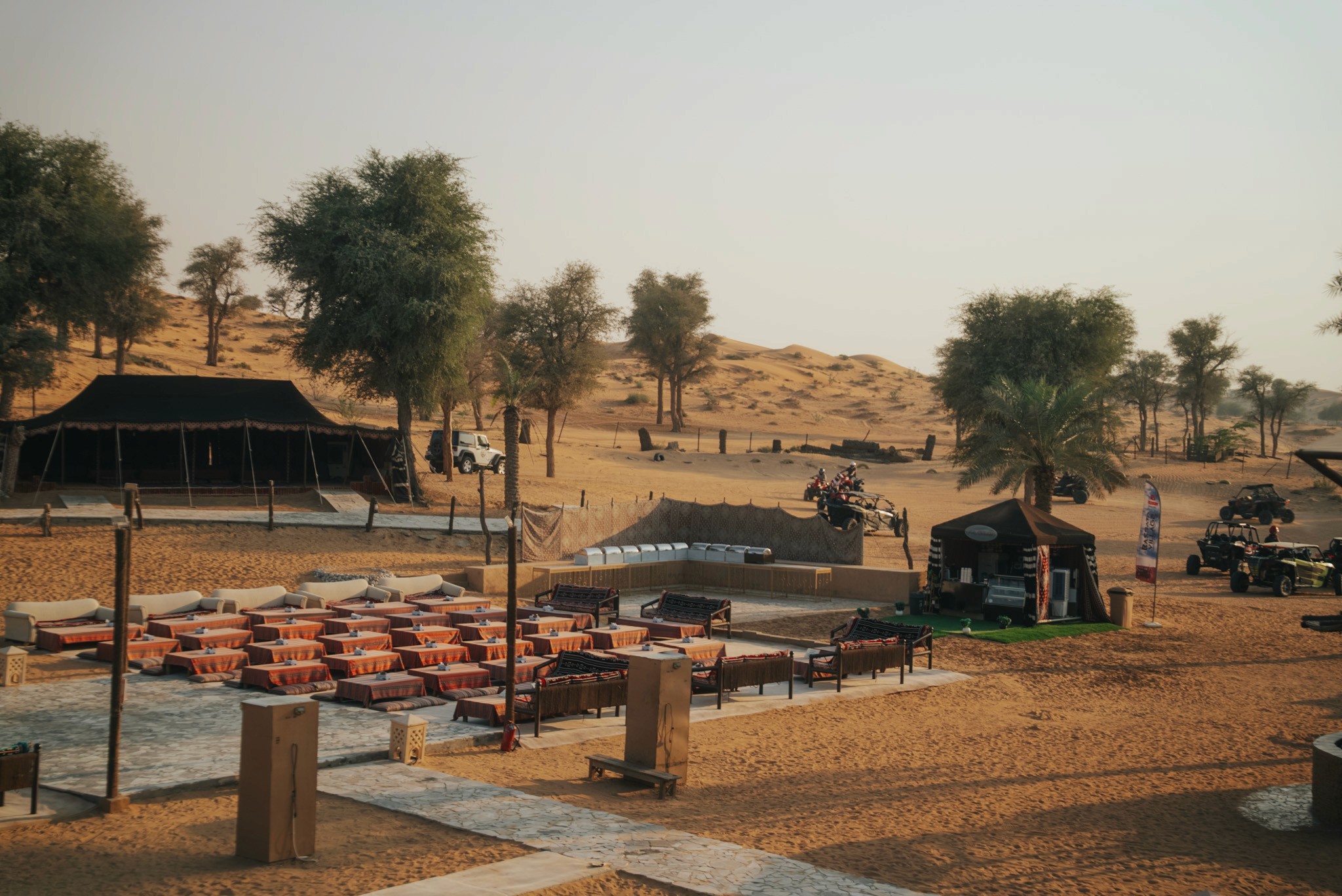 Woman adjusting safety goggles inside Can-Am Maverick X3 during Dubai dune buggy adventure with Dune Quest Tours in the red sand desert