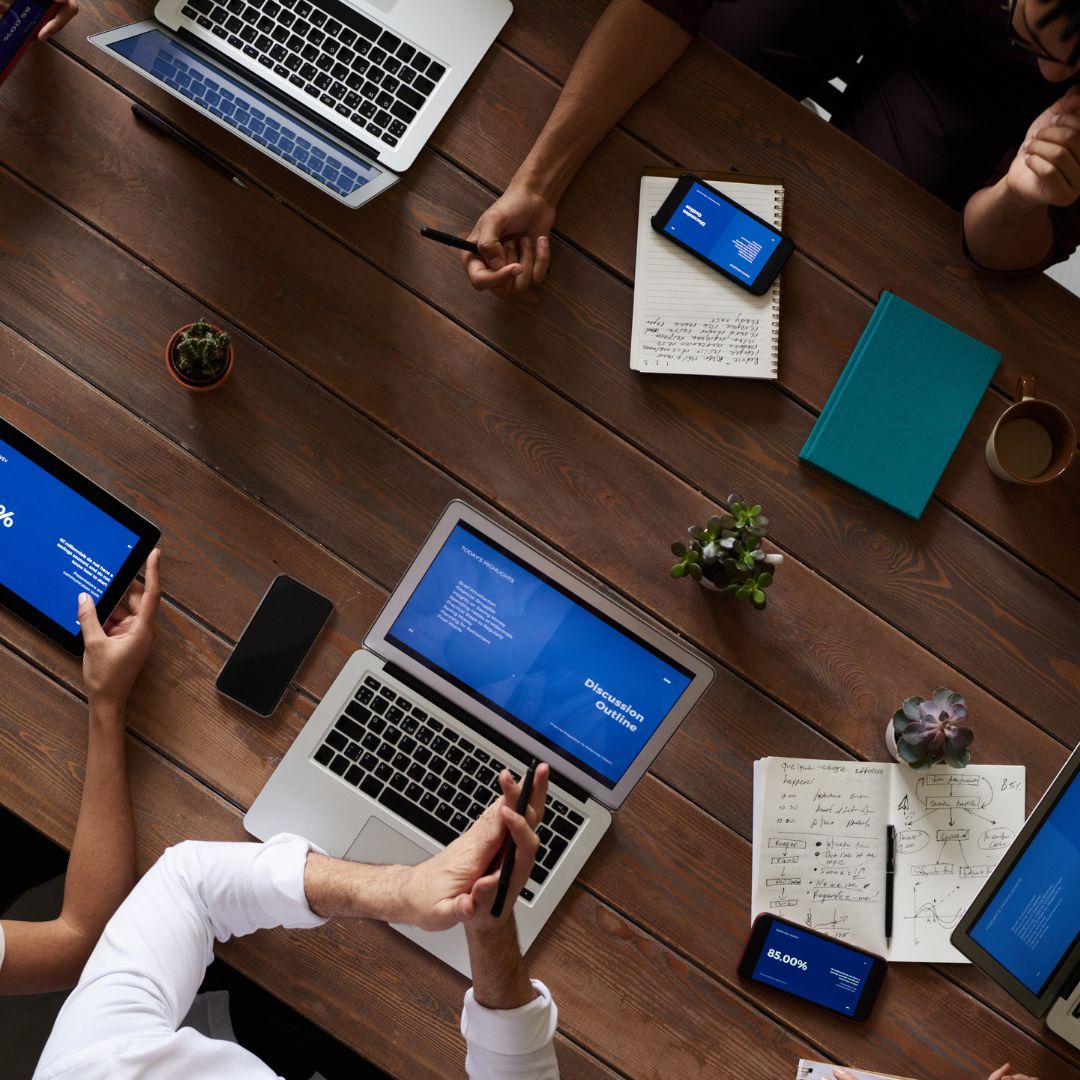 person holding pencil near laptop computer