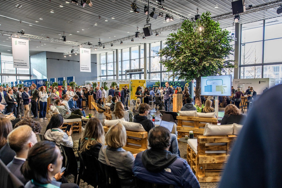 Drei Geschäftspersonen stehen an einem Konferenztisch und diskutieren intensiv