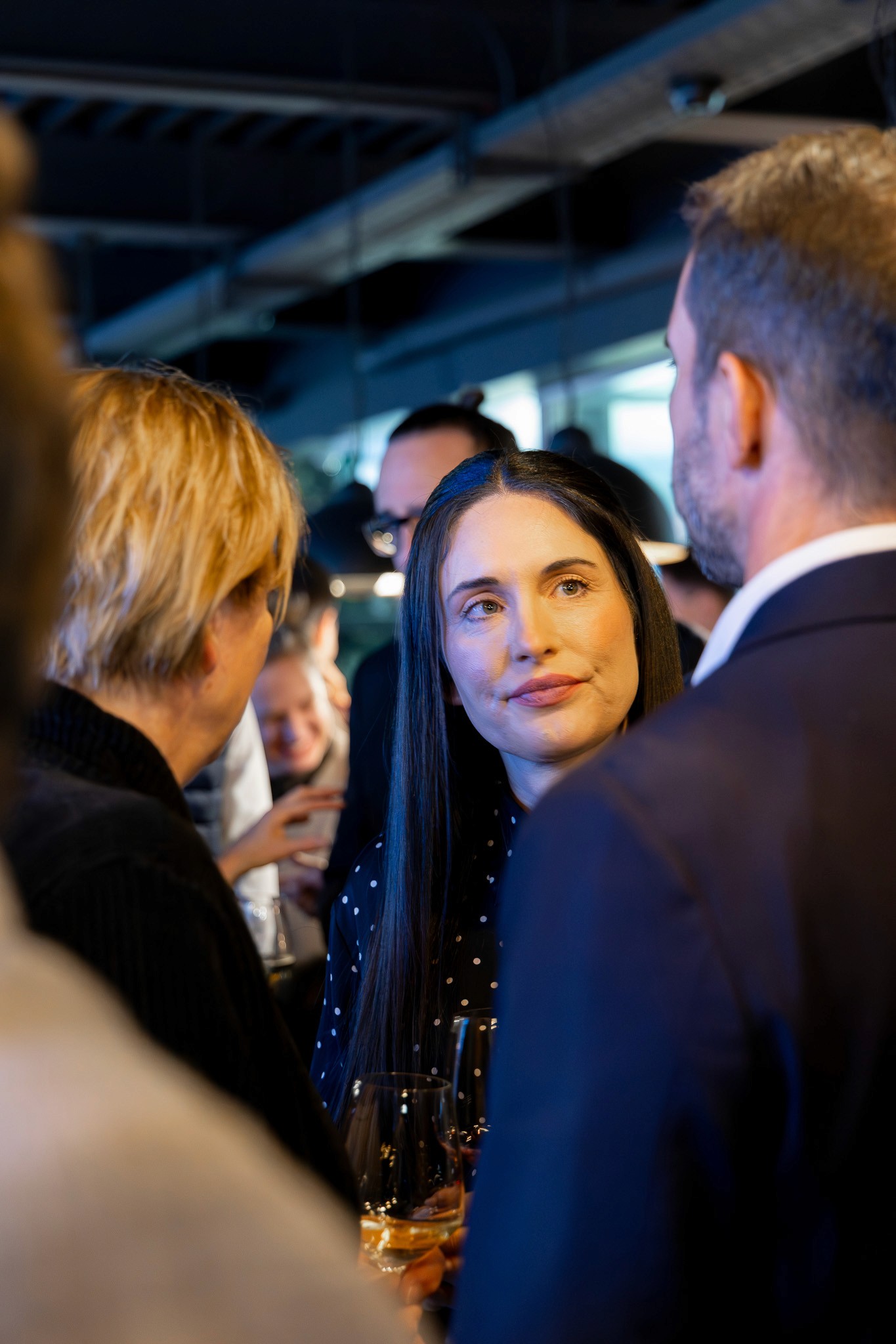 Woman networking with guests during an evening reception at CV Summit.