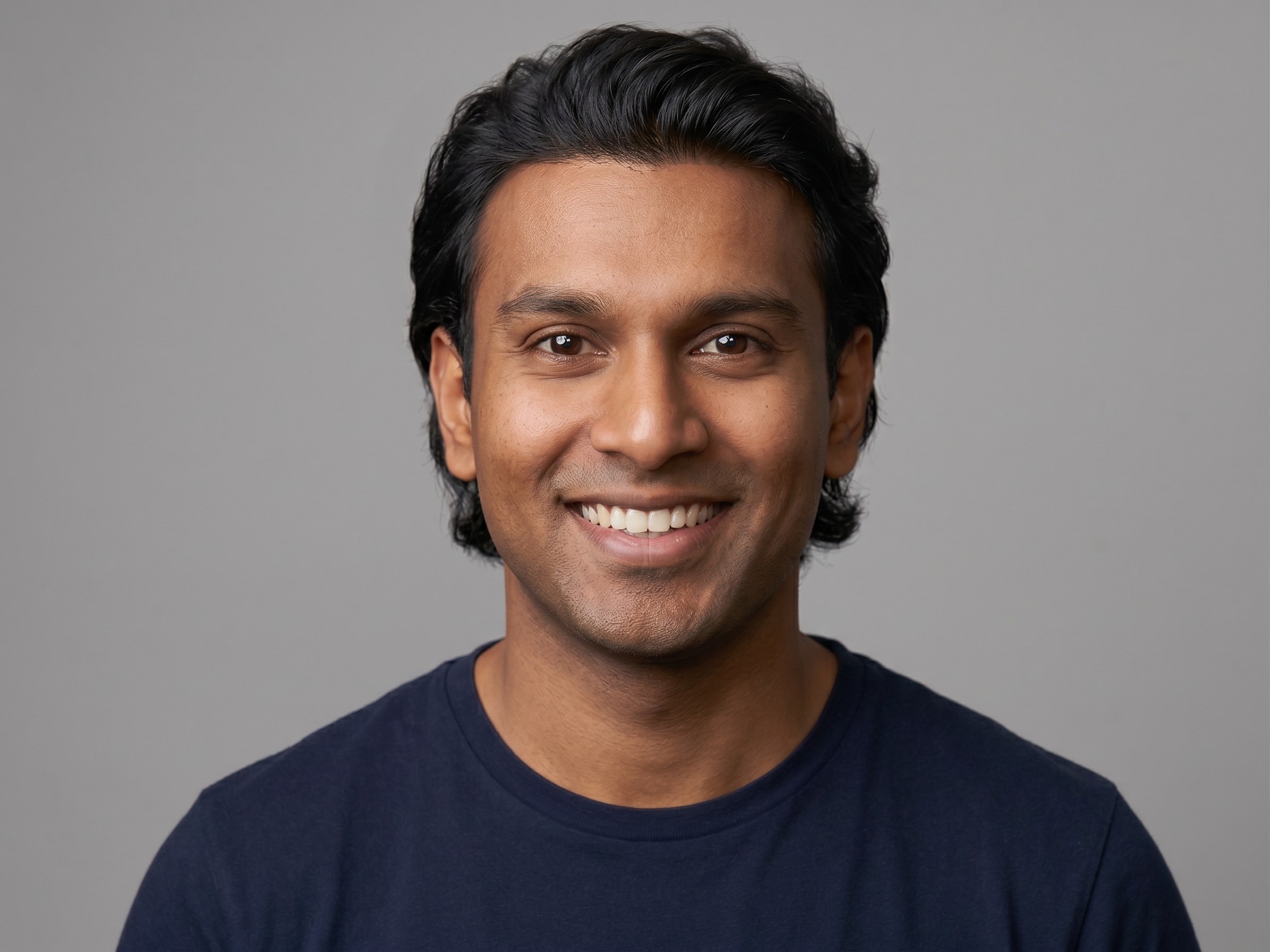 Person smiling and holding a cigarette indoors.