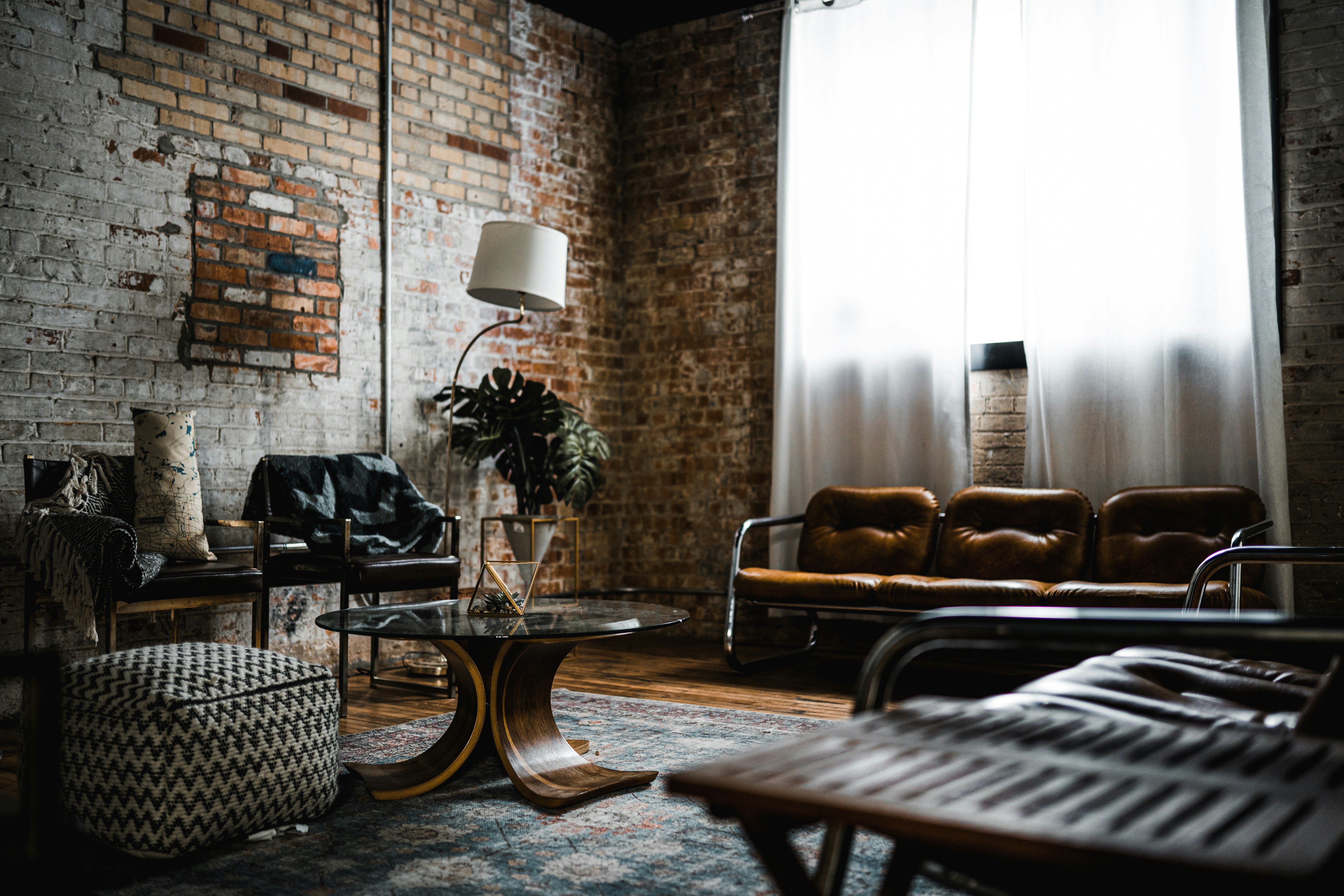 This room features a stylish blend of industrial and vintage decor, with exposed brick walls, modern furniture, and eclectic accents.