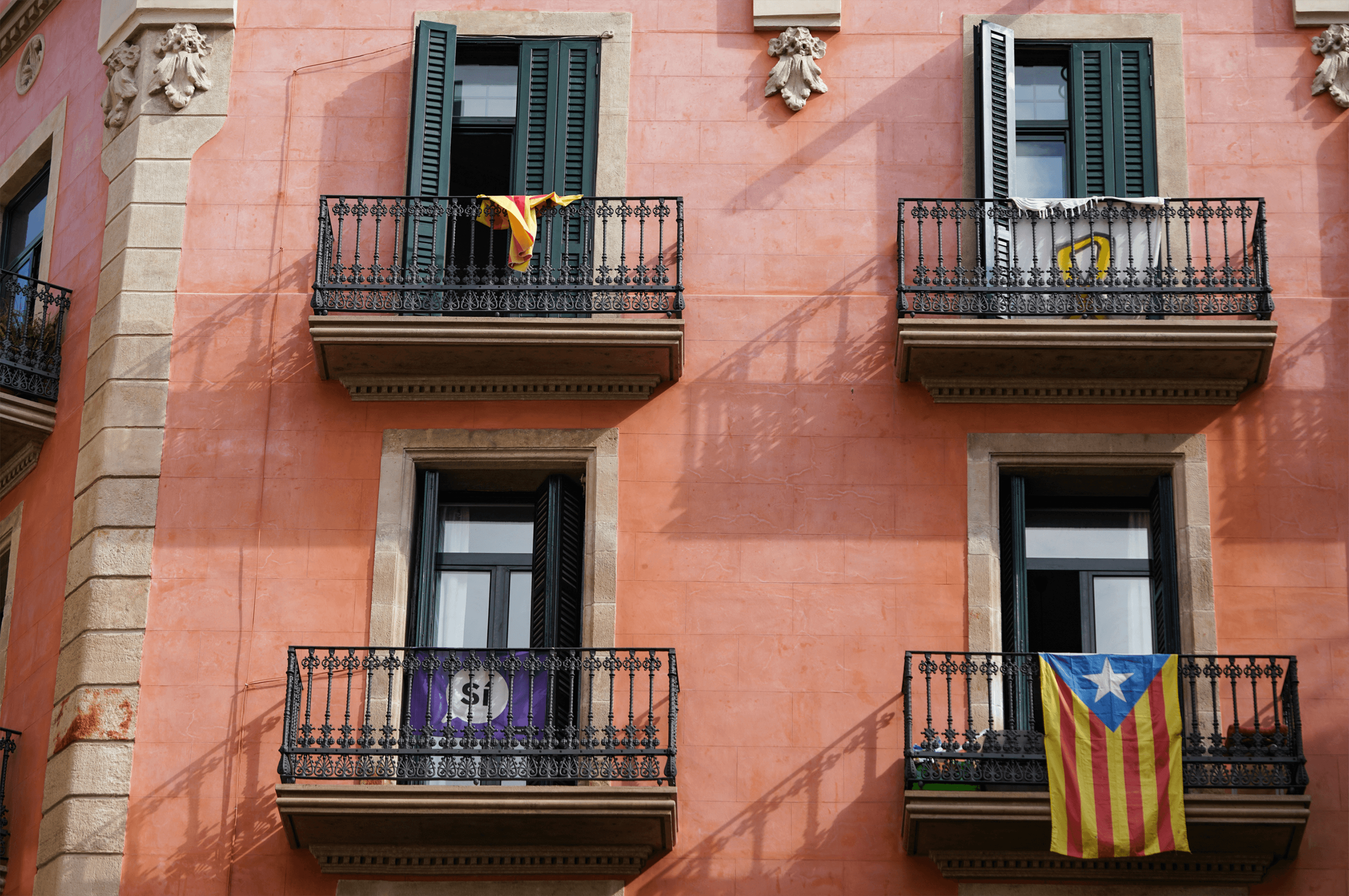 Gebouw in Barcelona met oranje pigmenten en de catalaanse vlag