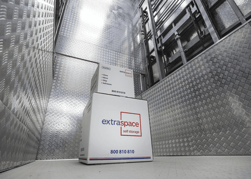 Boxes inside industrial elevator at Extra Space facility offering secure car storage options.