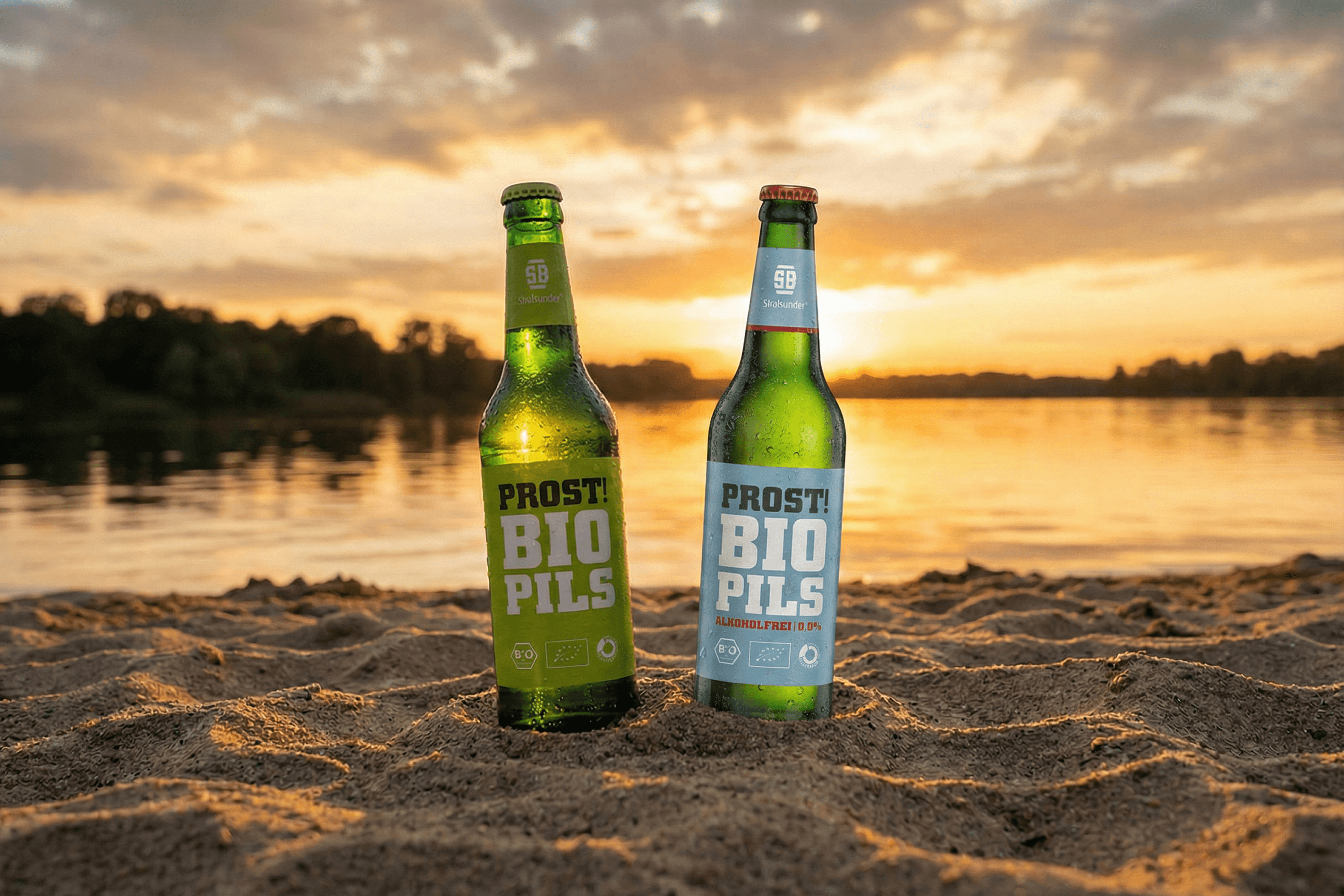 Two beer bottles on sand at sunset