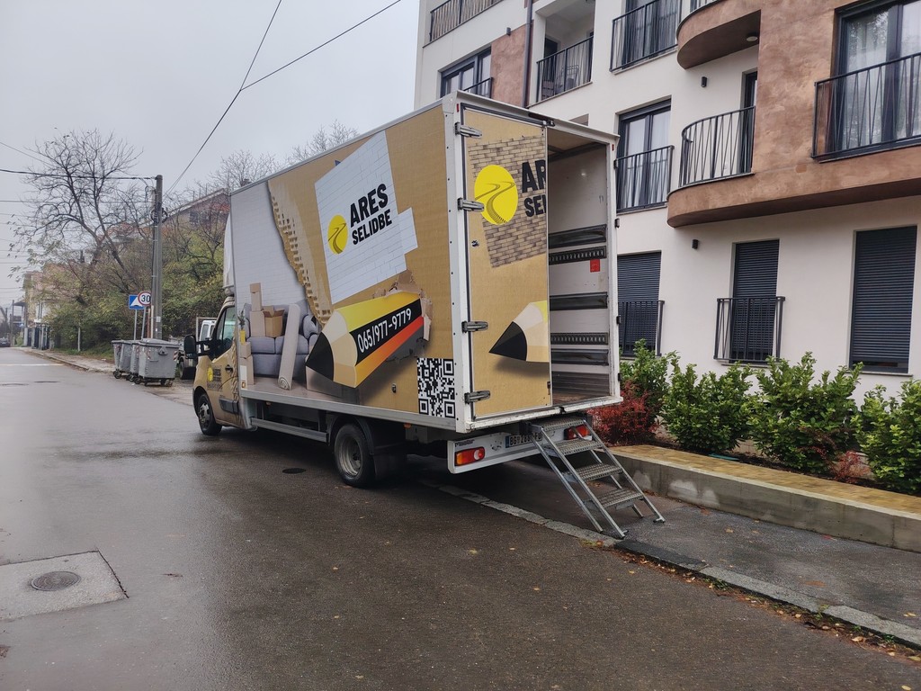 Teretni kamion Ares selidbe otvoren i spreman za utovar ispred stambene zgrade.