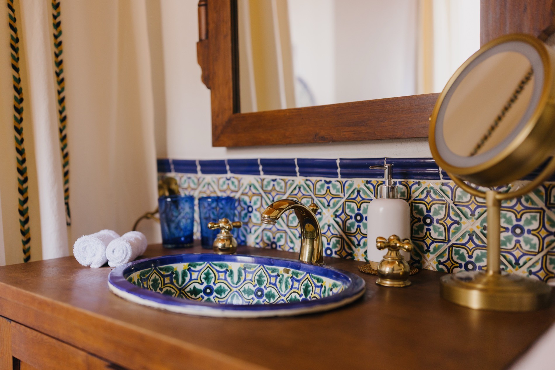 La Residencia blue Talavera ceramic sink with brass faucet and cobalt glass detail