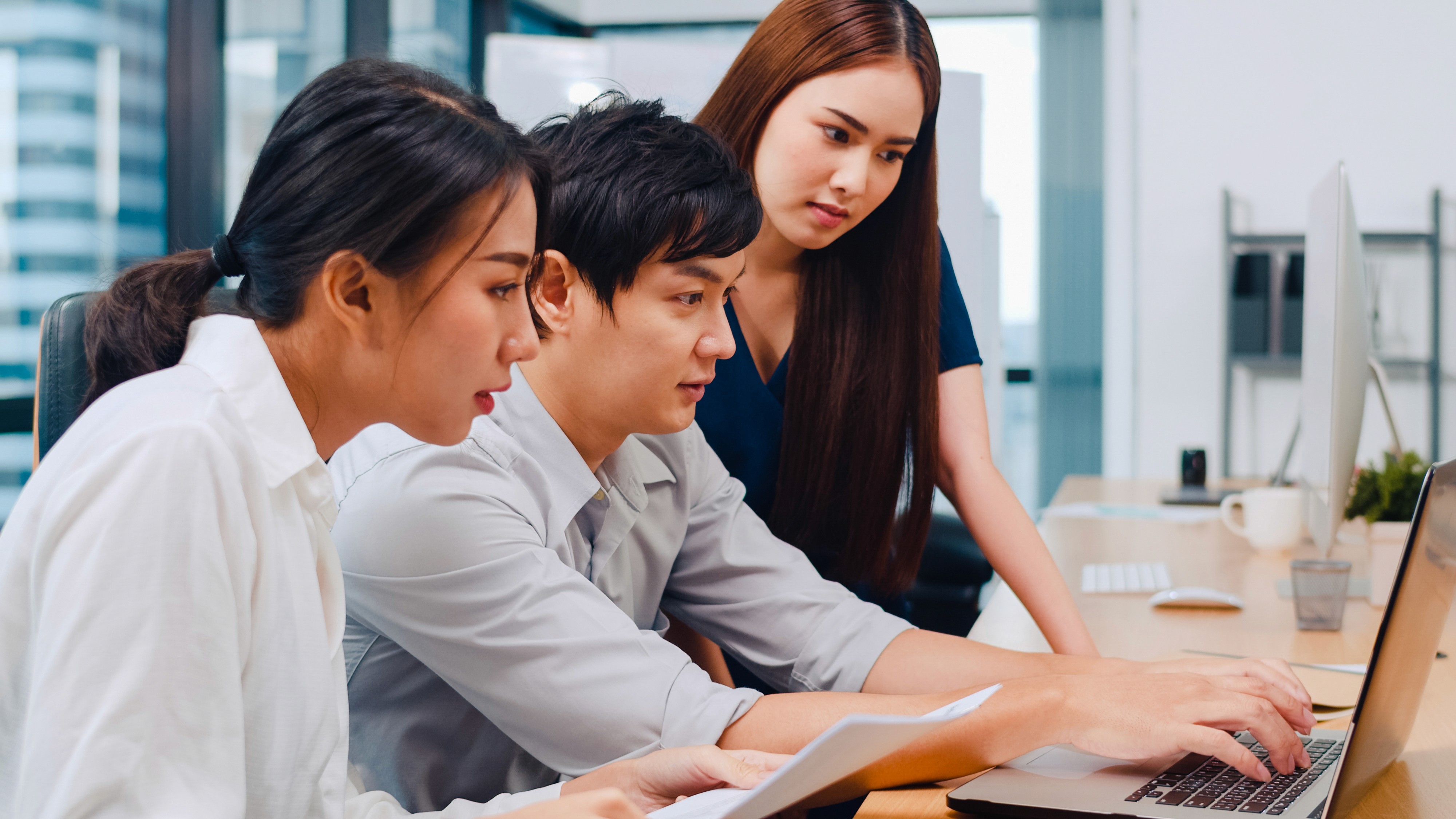 專業商務顧問團隊在辦公室討論企業保險方案，為香港中小企及跨國公司提供獨立專業保障建議40年保險經驗