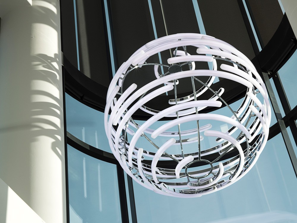 Close-up view of Deloitte Orb's machined and oven-formed opal acrylic profiles with seamless chrome finish