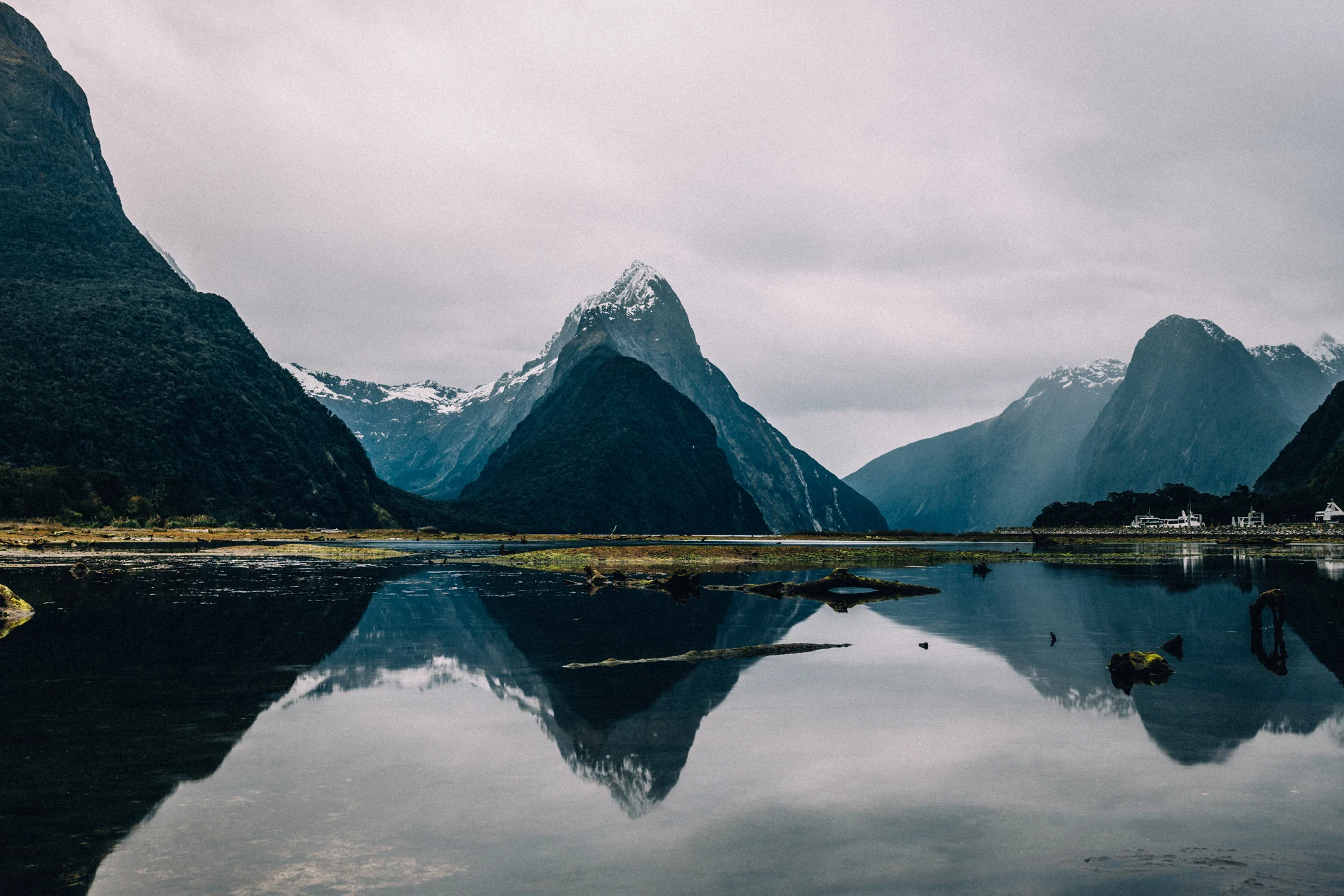 A steep peak reflected in still water under heavy grey cloud