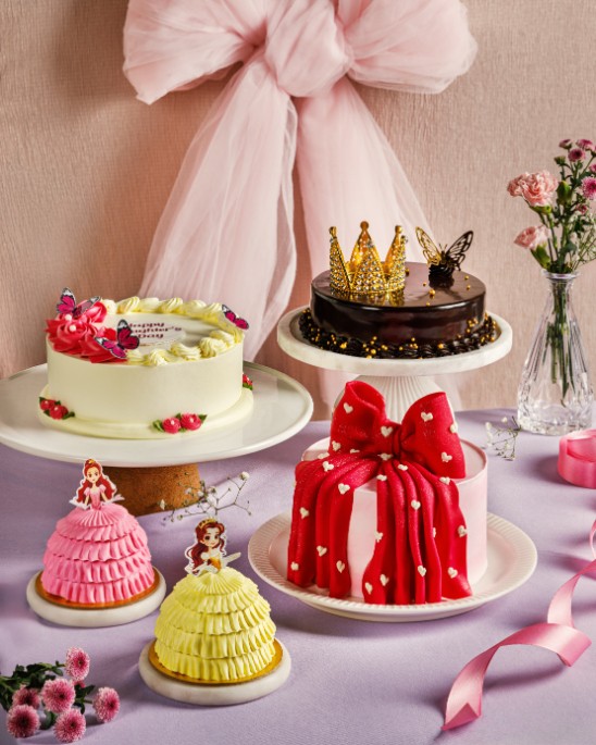 Ribbons and Balloons' lifestyle shot of a celebration cake spread with doll cakes