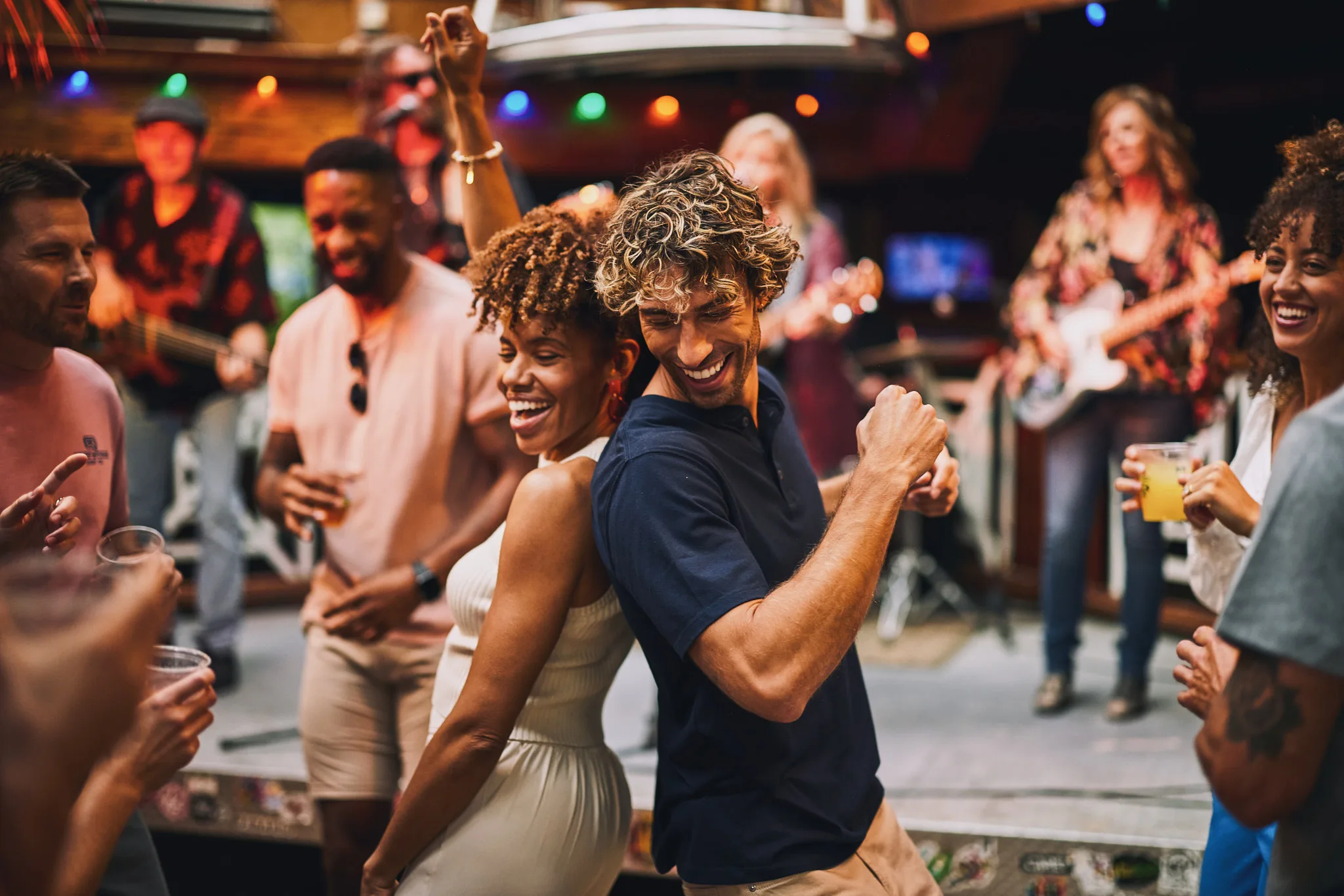 couple dancing back to back at bar — lifestyle photography by Tom Kubik
