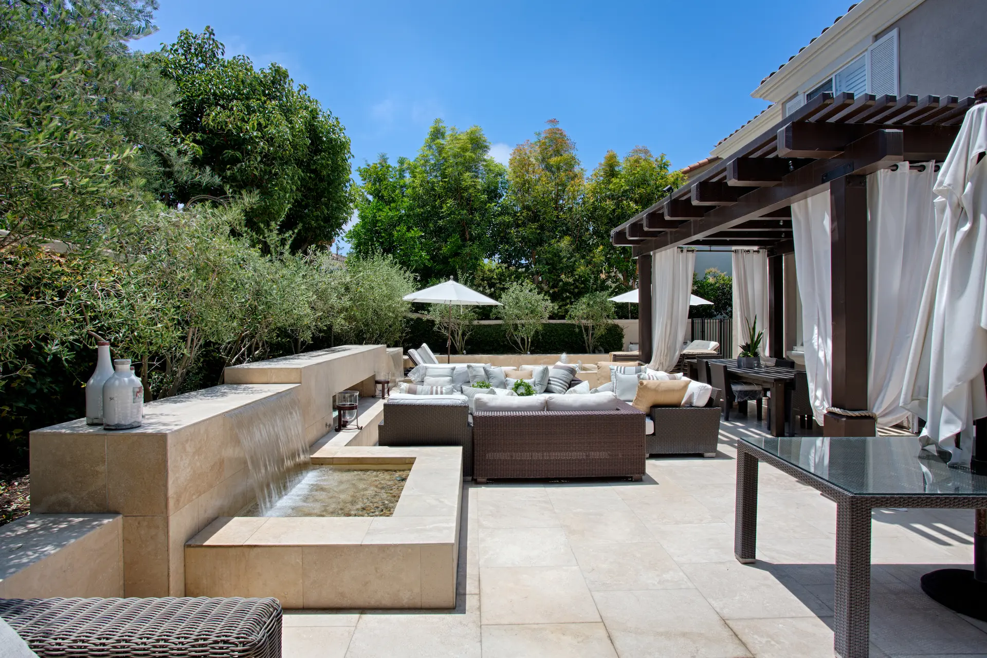 Outdoor patio area with built-in spa, pergola, and lounge furniture in Newport Beach Remodel.