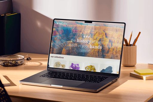 Laptop siting on a desk with the homepage for Fossil Era.