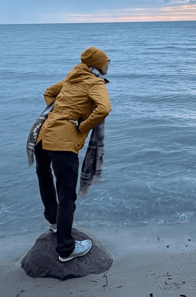 Close-up of a dark green leaf showing its textured surface and central vein against a muted background.