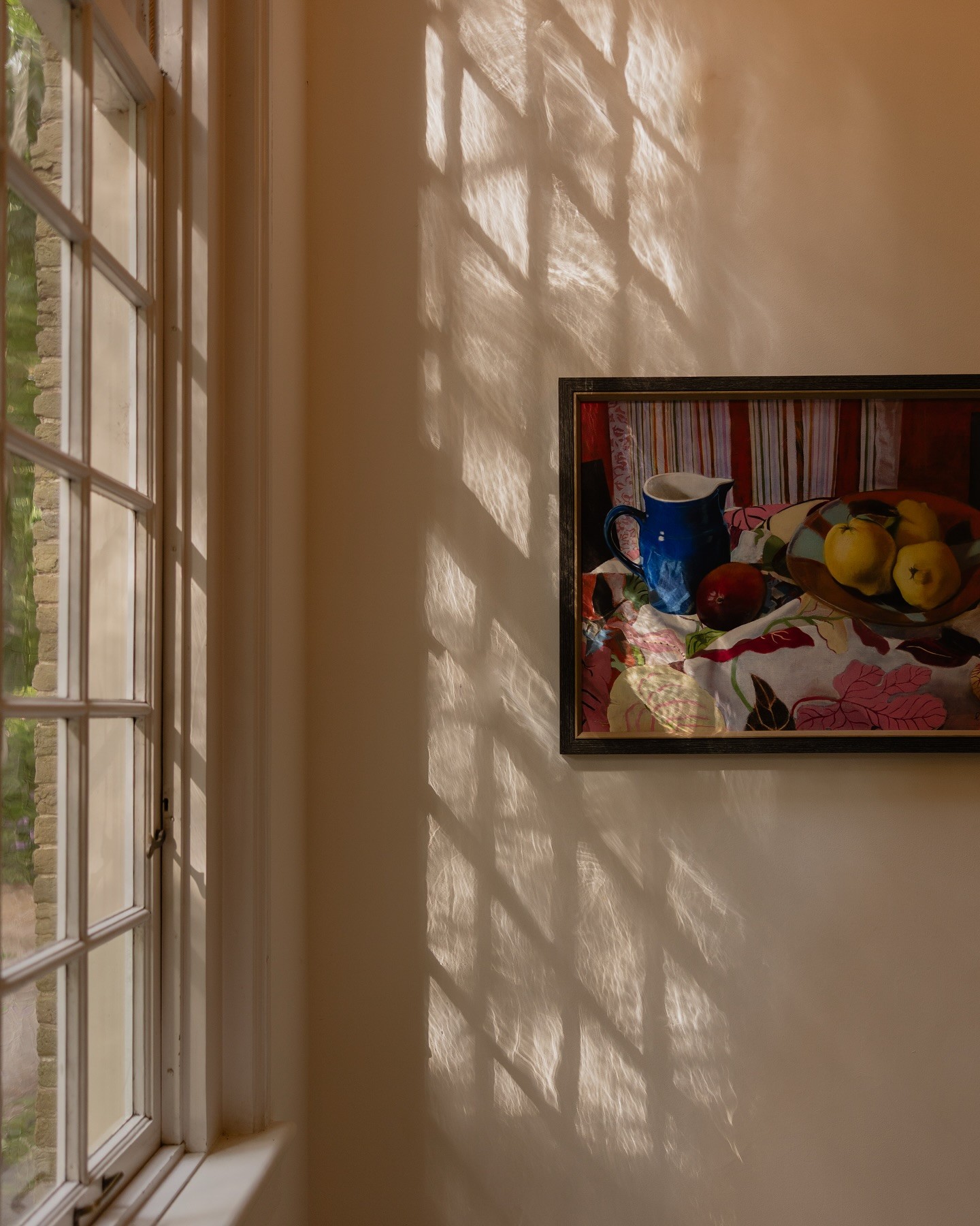 Sun reflections on the wall with a painting
