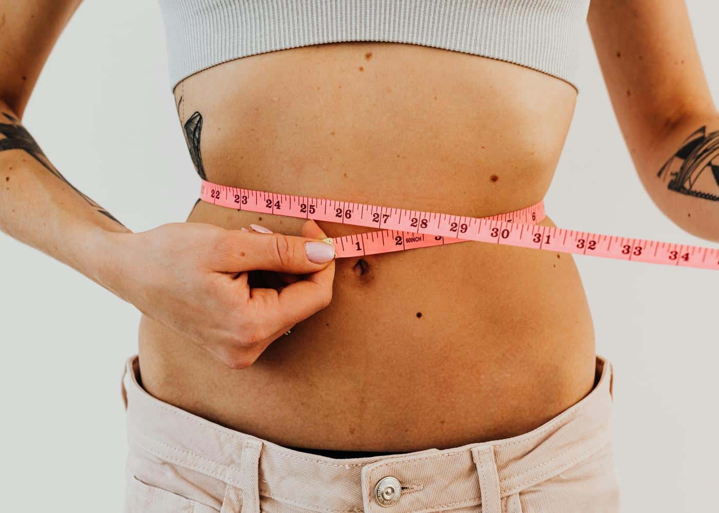 Finding the right weight loss drug - Woman measuring her stomach circumference