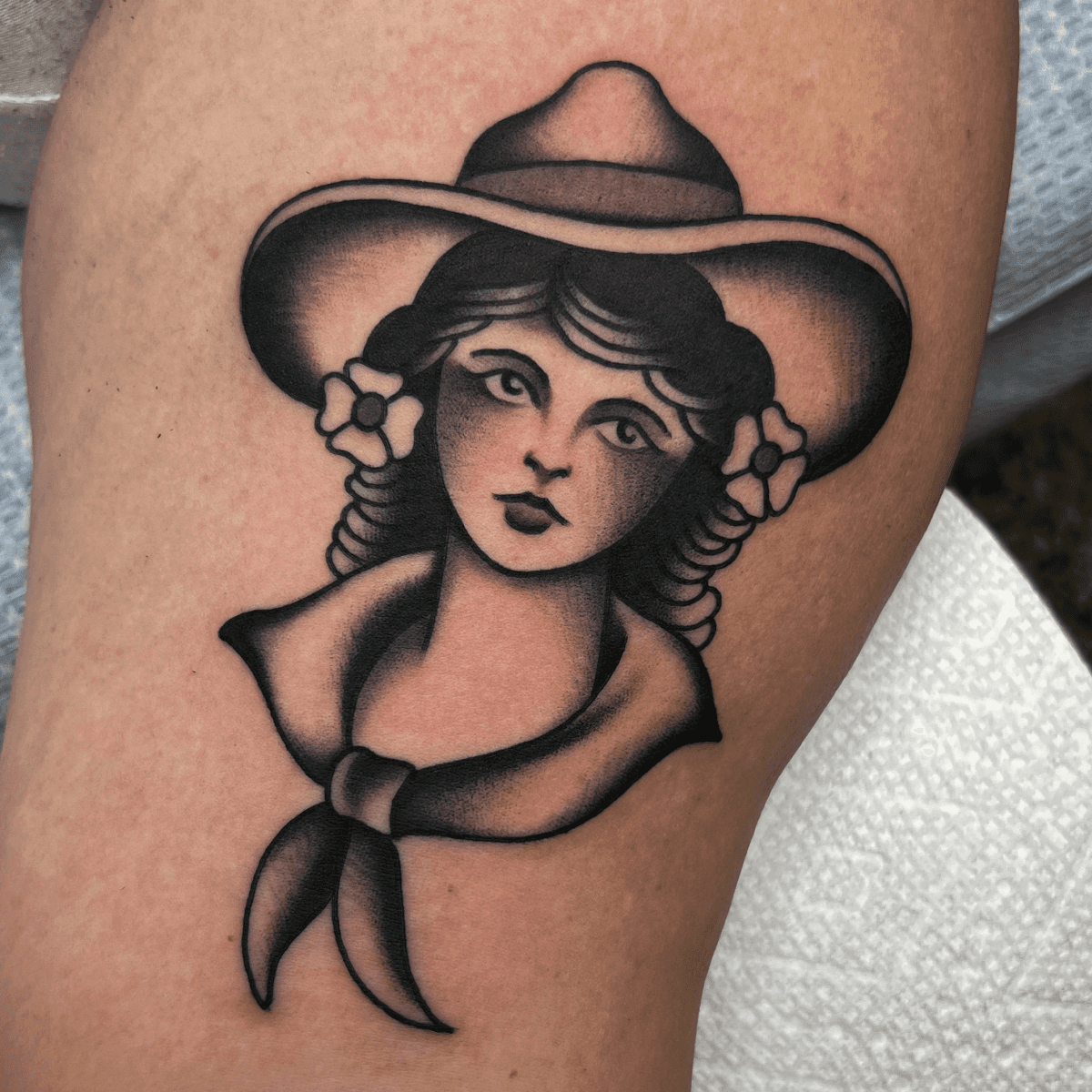 black and gray tattoo of a cowgirl head