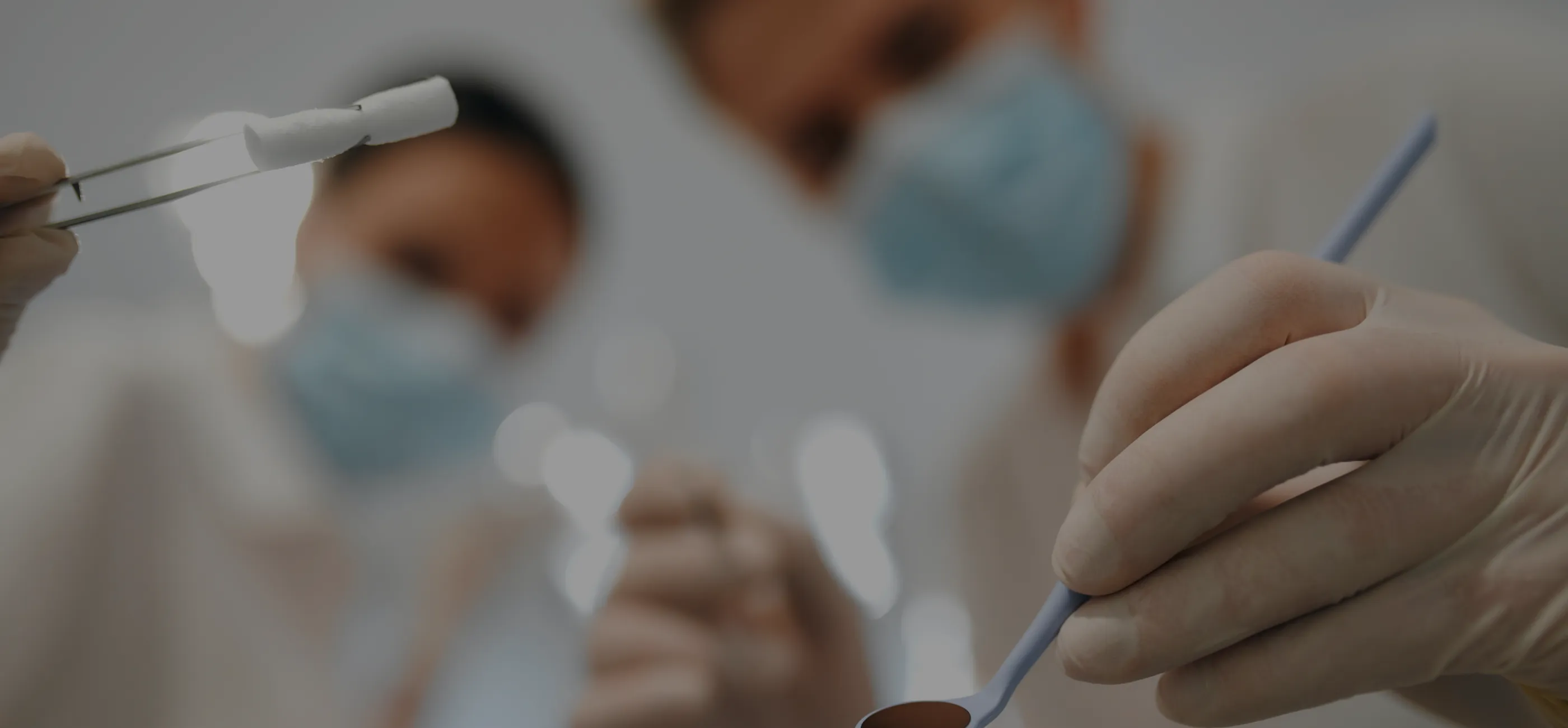 Stomatolodzy pochylający się nad pacjentem.