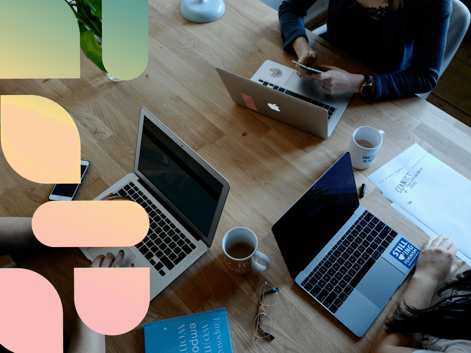 Three people working on macbooks