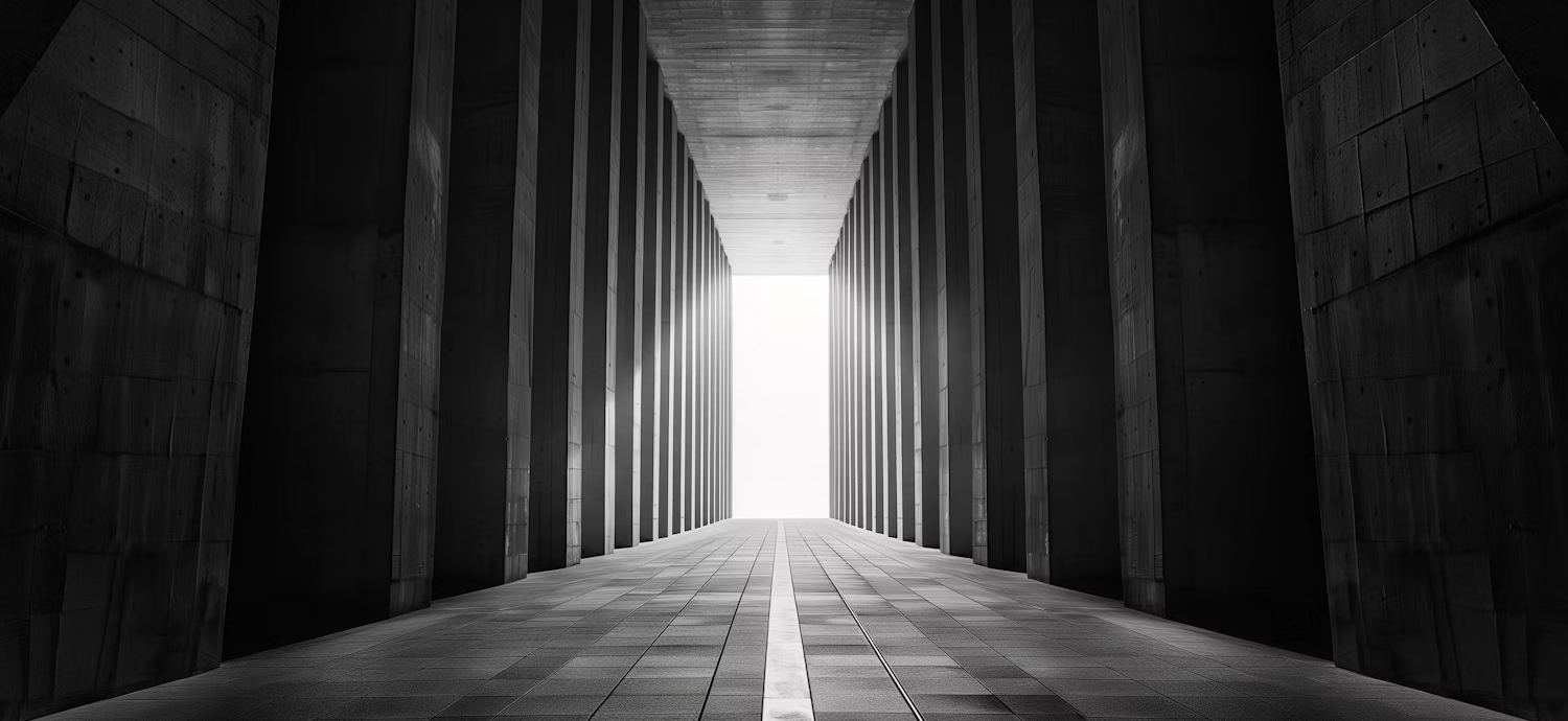 Colonnade of concrete pillars leading to light