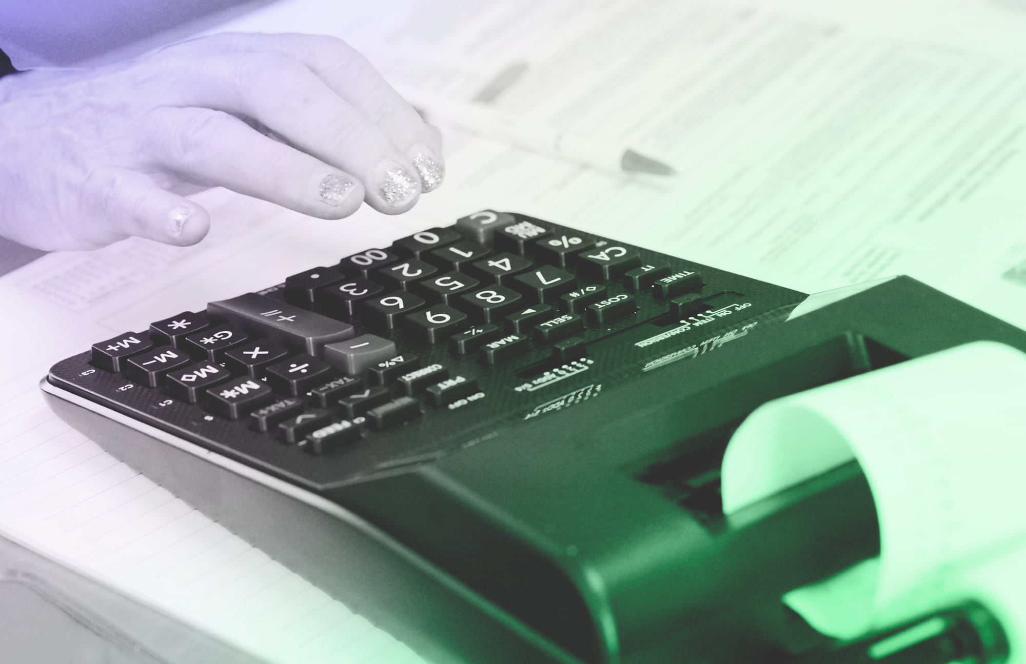 Business owner reviewing financial figures on a calculator and printed receipt during bookkeeping