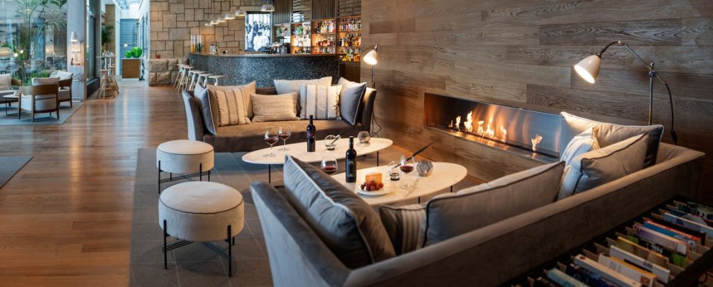 Gemütliche Lounge mit Sofas, Kamin, Kaffeetischen, Wein und Snacks. In luxuriösem Ambiente. Perfekt für Entspannung und Genuss.