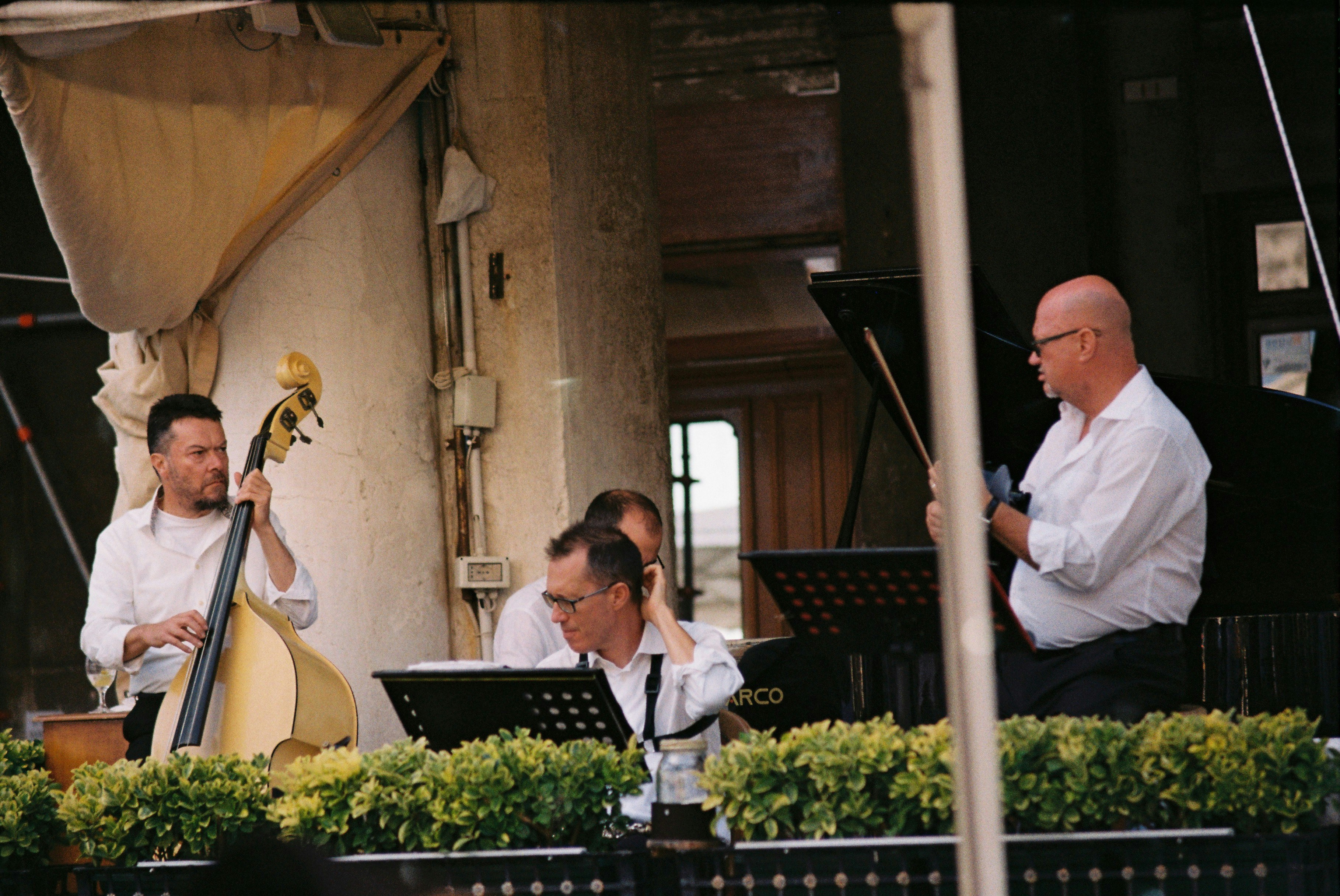 Musicians performing jazz music outdoors with piano and bass.