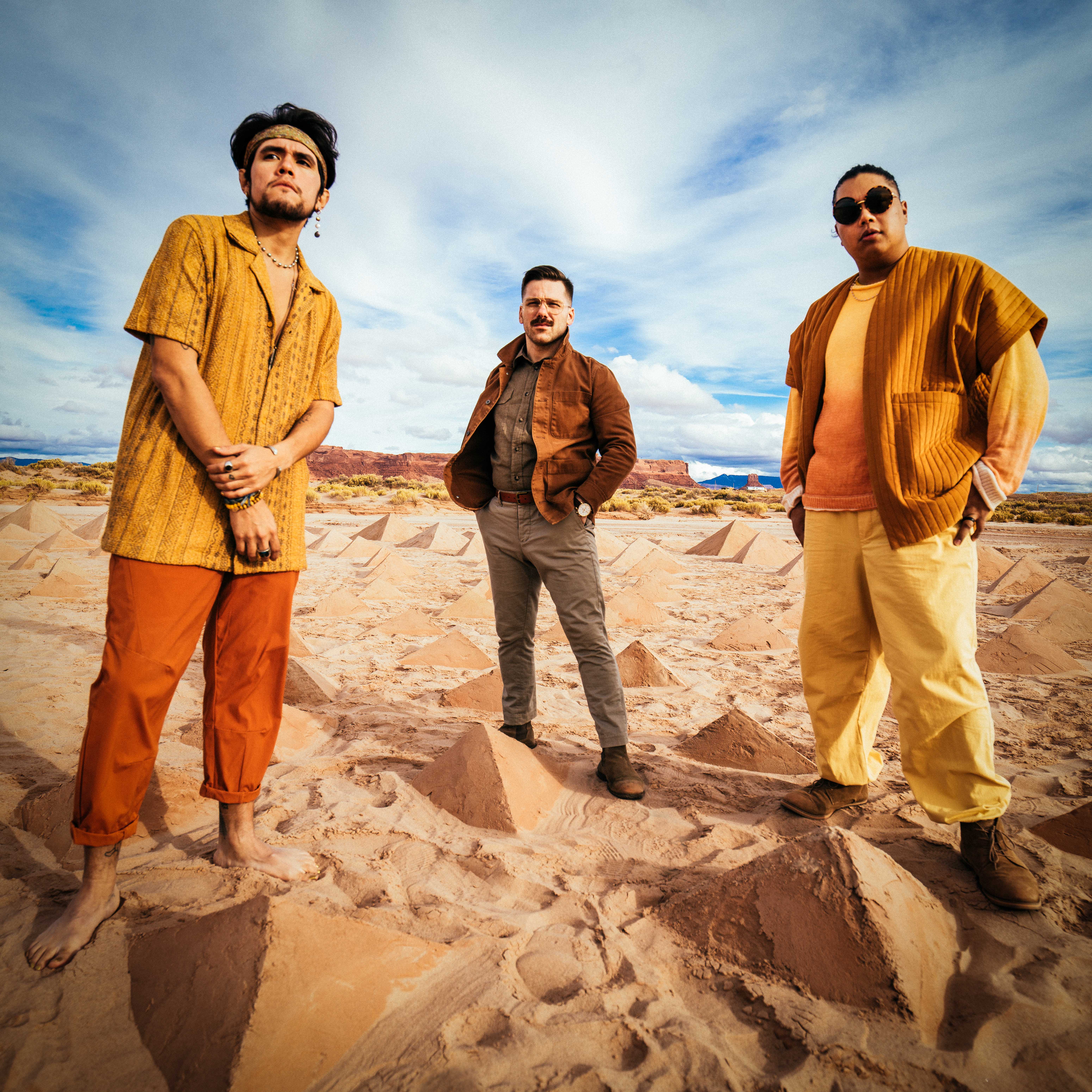 The band A R I Z O N A standing in front of pyramids made of sand in Navajo Nation, Arizona