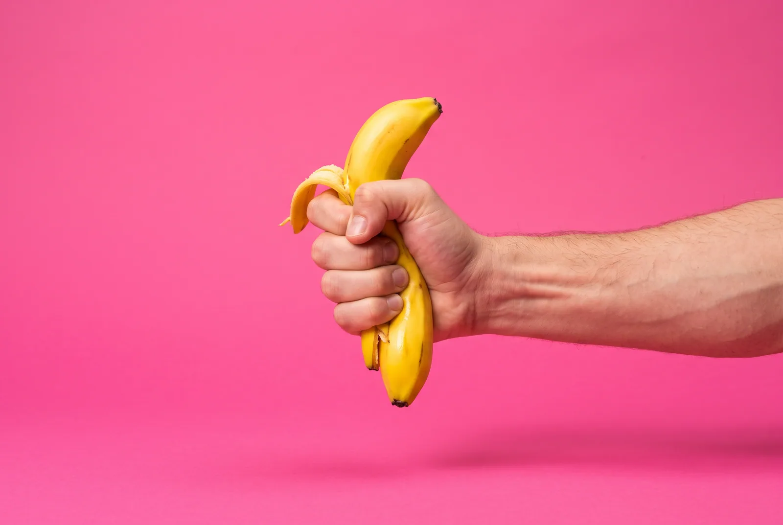 A man's fist squeezing a banana tight, a playful image for death grip syndrome