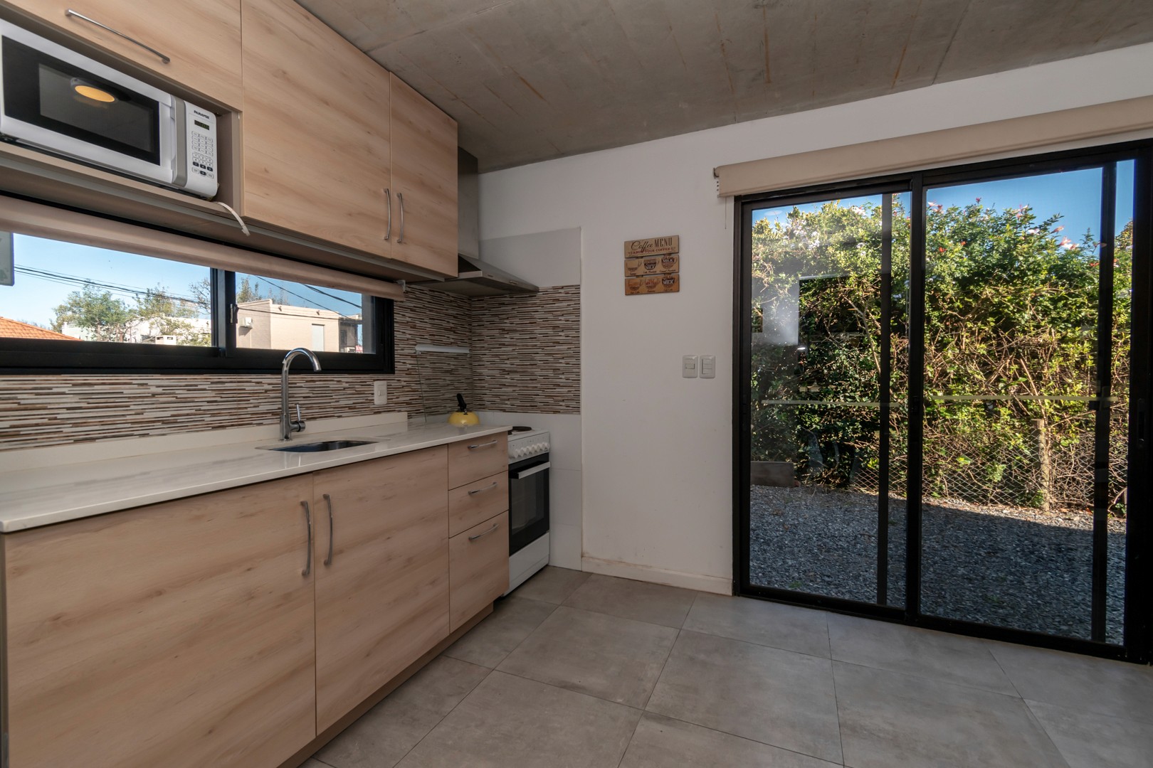 Cocina de estilo contemporáneo en Casa Horneros - diseño limpio y moderno en el corazón del hogar.