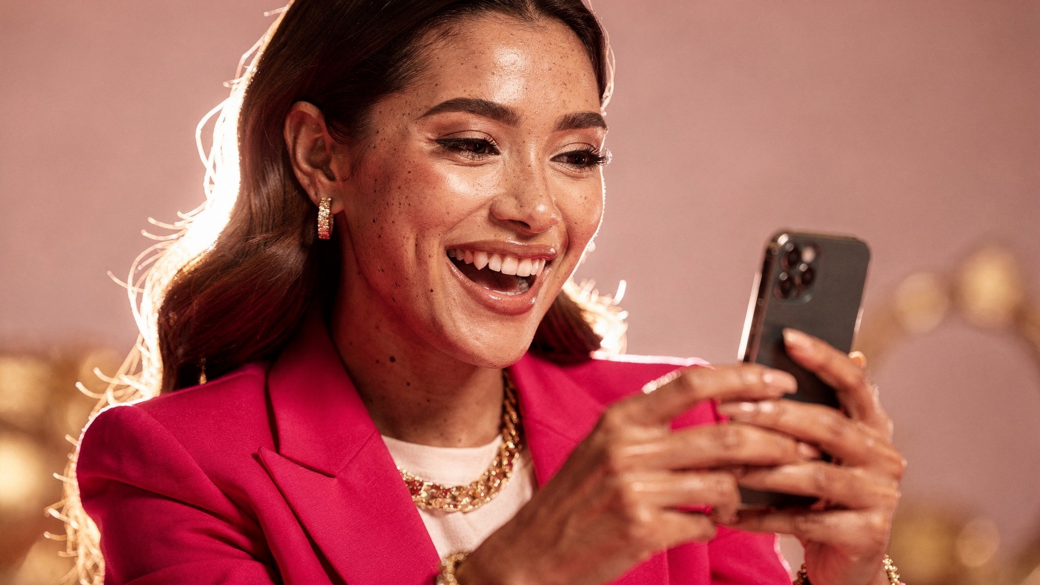 Adult beauty creator looking at phone with genuine reaction, soft pink studio lighting