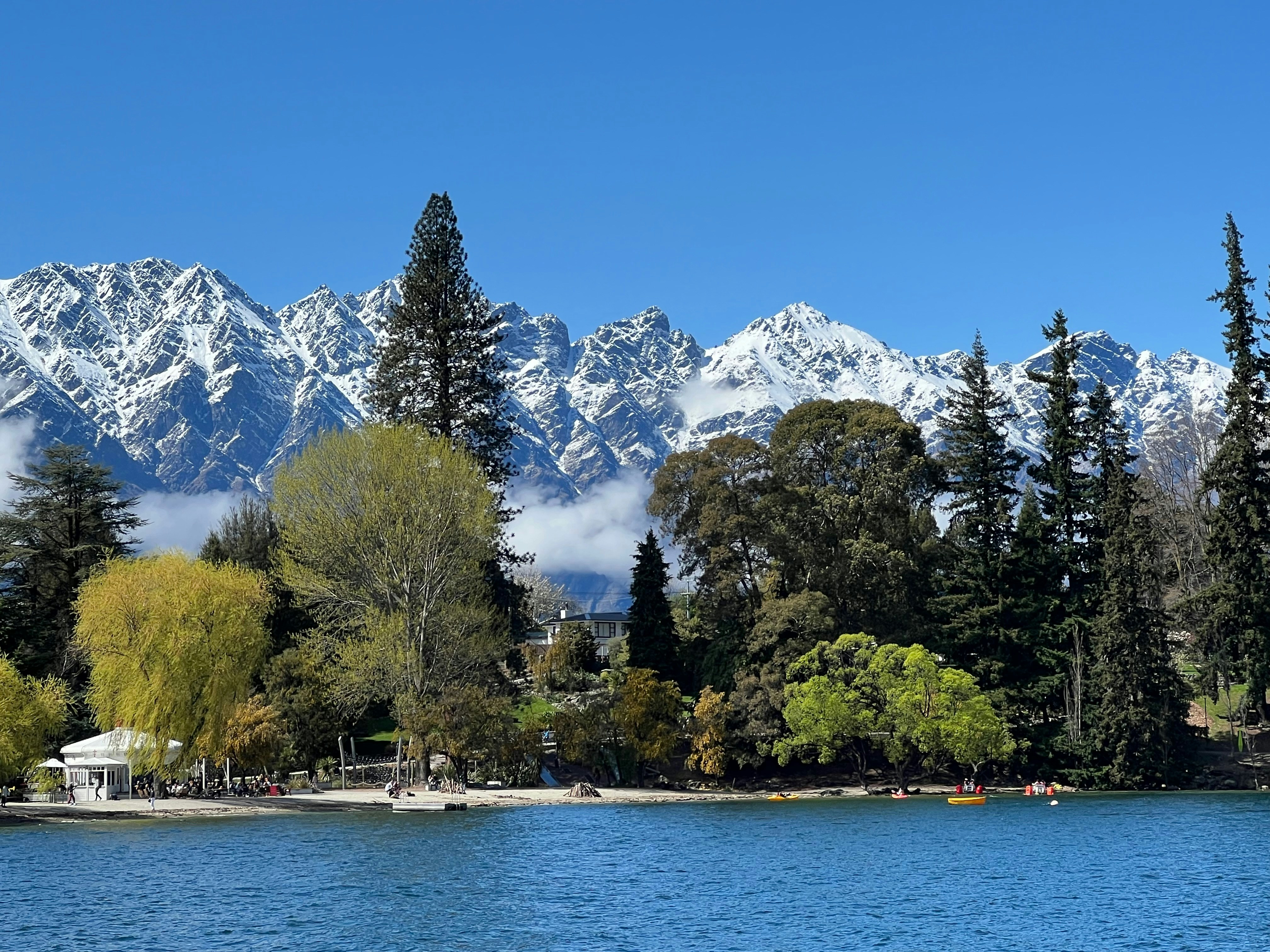 A lake surrounded by trees with mountains in the background