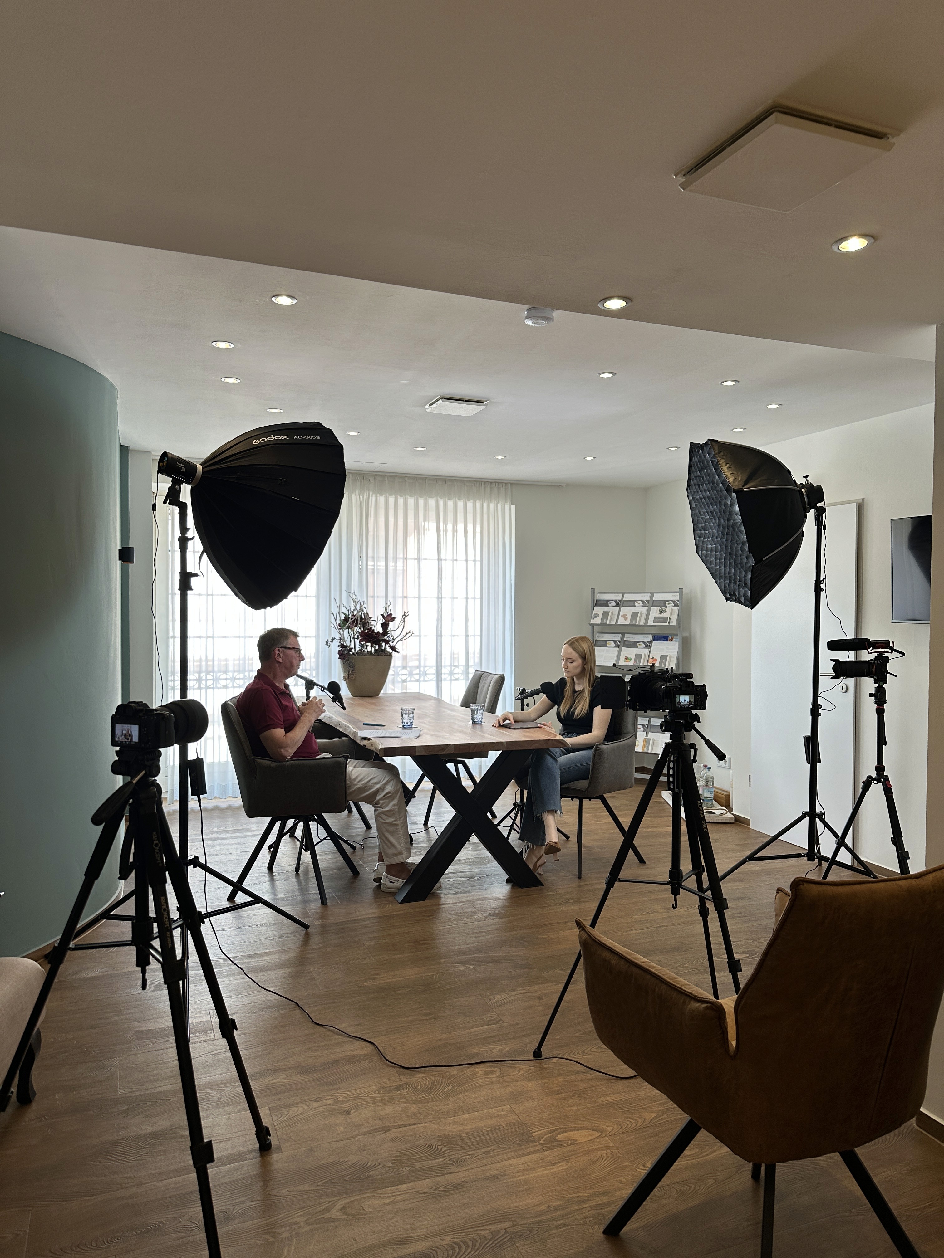 A woman wearing a purple sweater holds a green smartphone and smiles warmly under a clear blue sky, conveying happiness and connectivity.