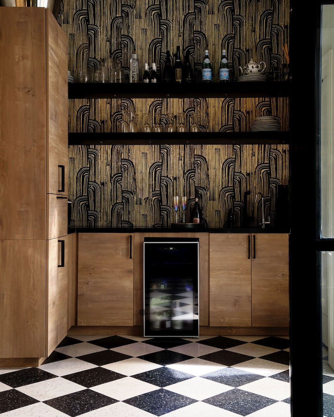 Forte Deux retail interior with custom bar cabinet, patterned wallpaper, and black and white checkered flooring.