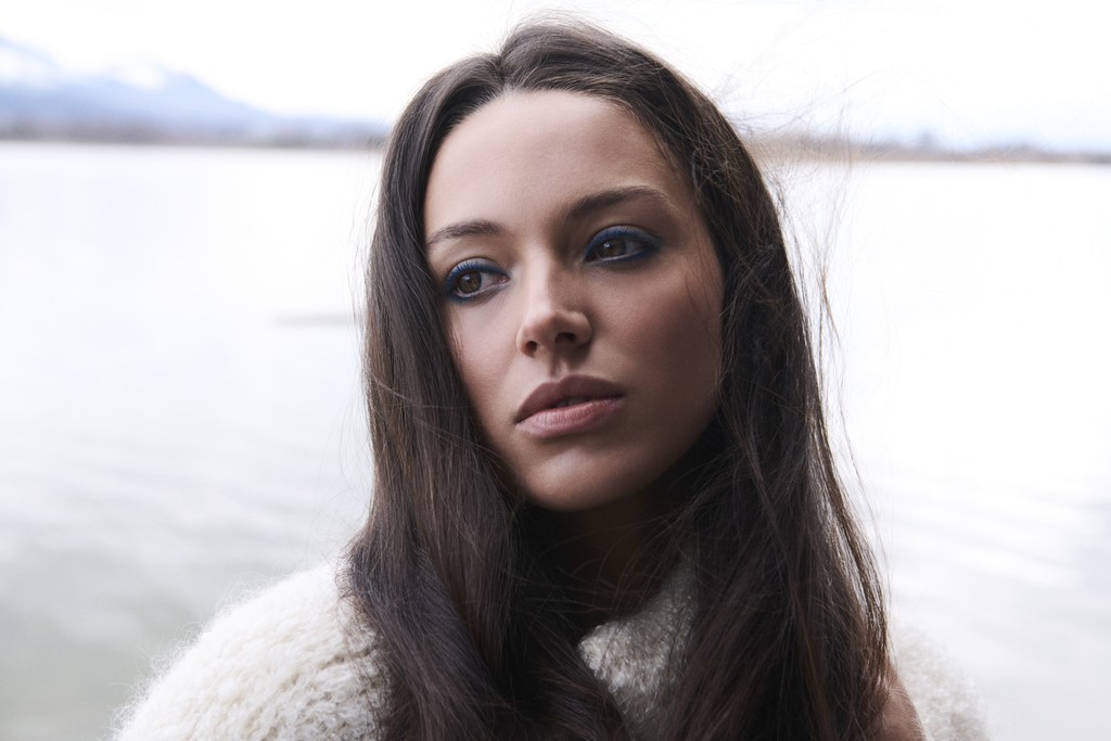 A man stading with Surfboard