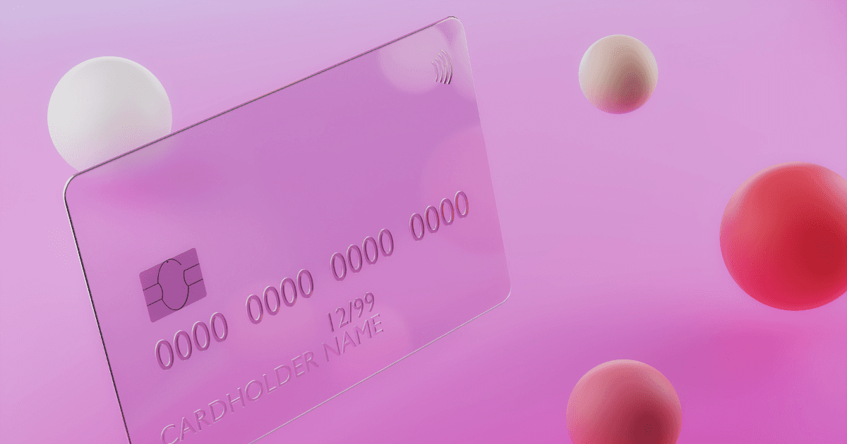 A credit card on a pink background with spheres surrounding it