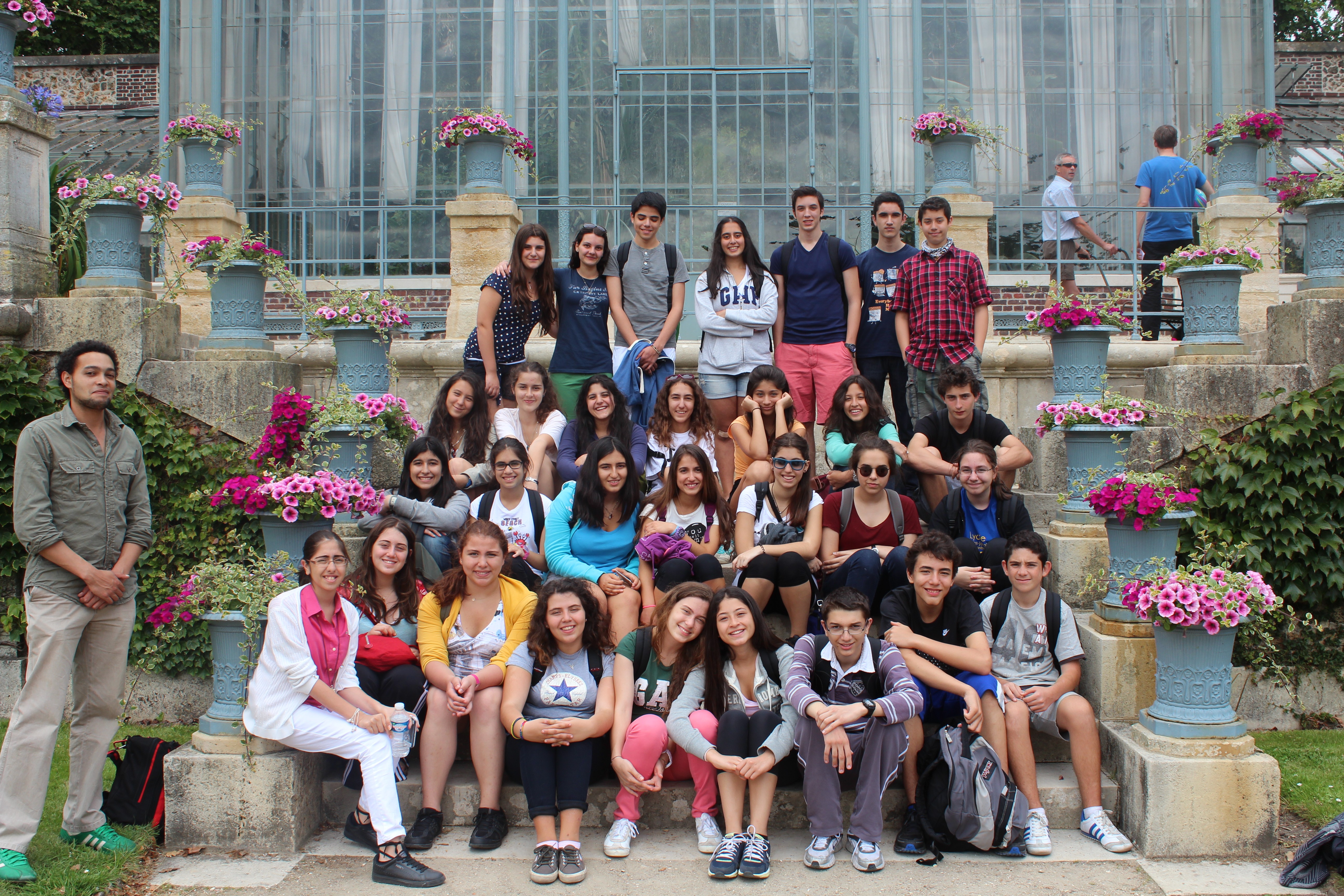 People walking down a street lined with palm trees.