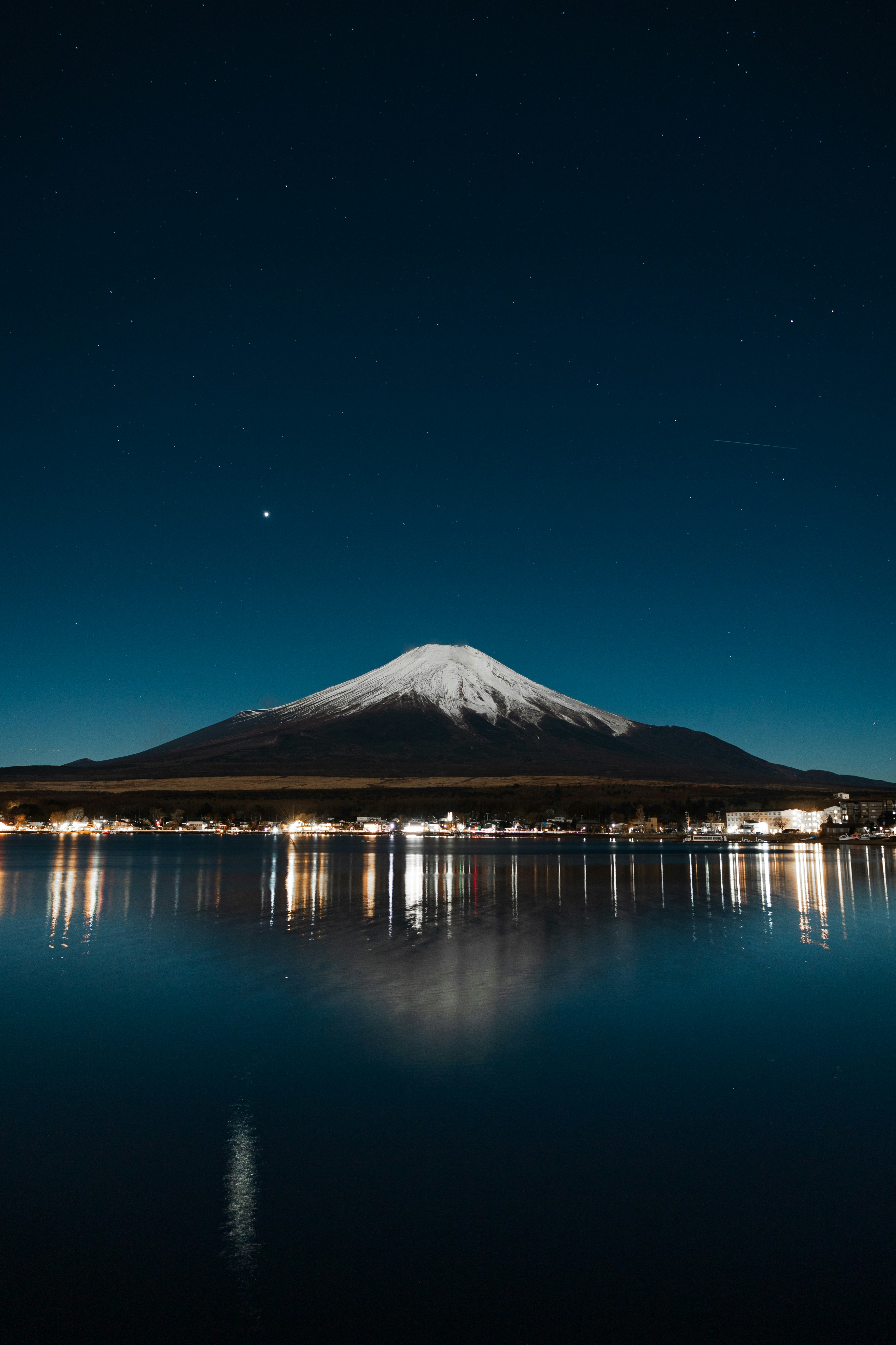 Mount fuji, lake reflection under a starry sky.