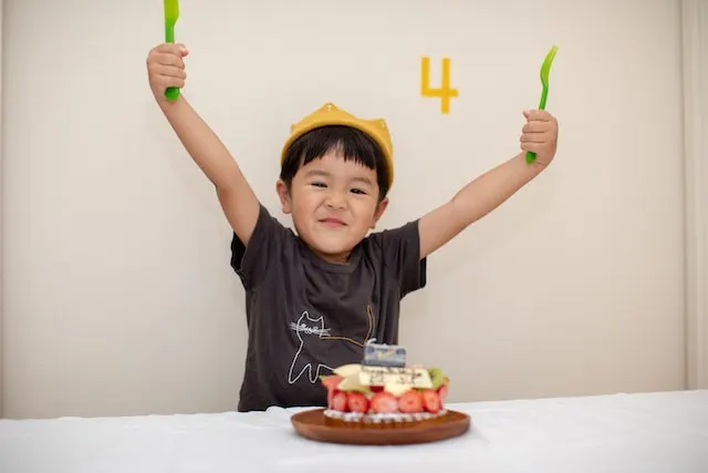 A Southeast Asian boy celebrating his birthday with a piece of strawberry pie