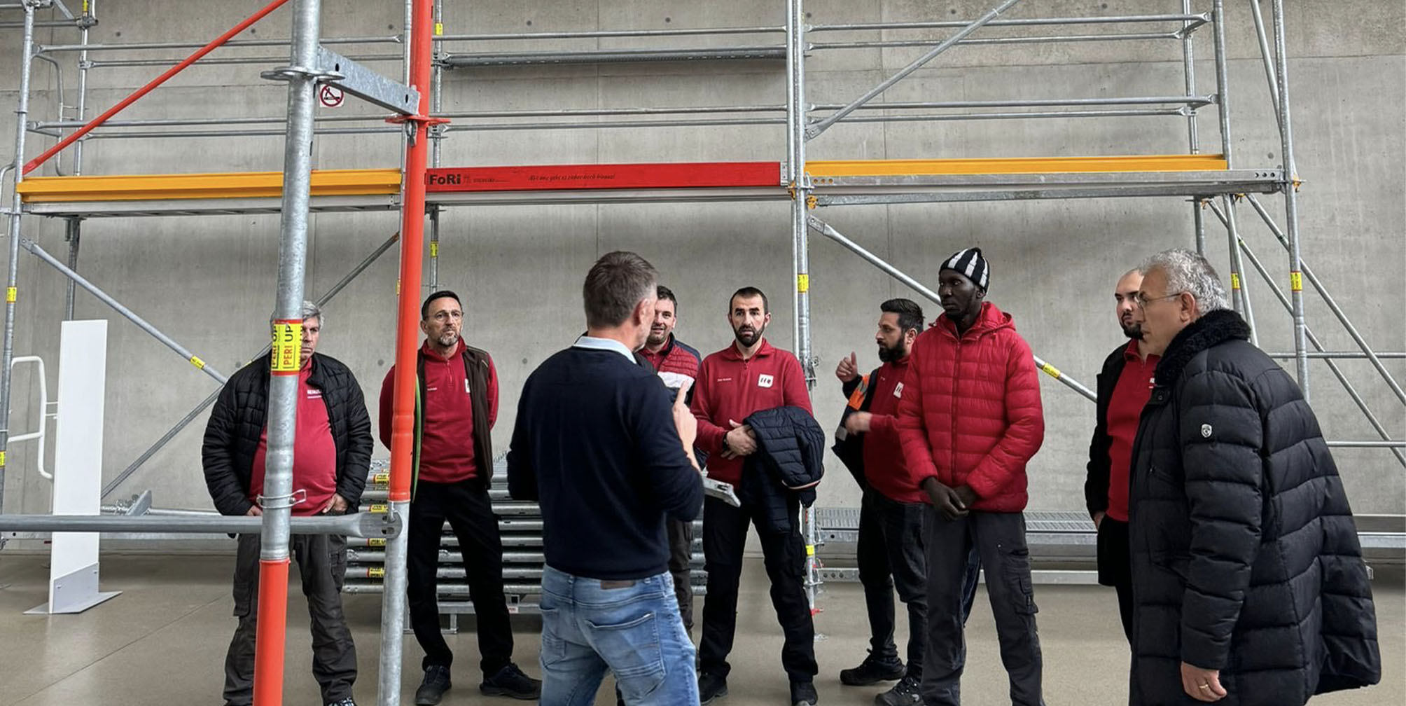Woman looking at a computer screen in warm natural light, focused and thoughtful, with sunlight casting soft shadows on the wall behind her.