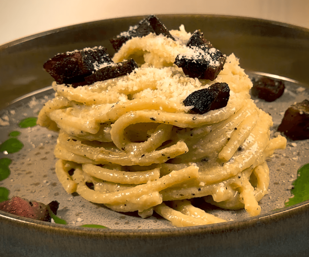 Twirled pasta plated with gauncale and cheese